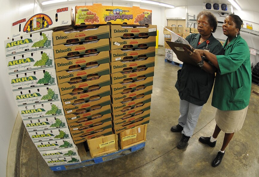 BARKSDALE AIR FORCE BASE, La. - Edith Banks (right), Commissary produce manager, shows Alberta Hall (left), store associate training in produce, where the quantity goes on the inventory checklist Aug. 9 at the Barksdale Commissary. Trucks deliver fresh produce in the early morning Tuesday through Saturday every week and employees must receive and quality control all products. (U.S. Air Force photo/Senior Airman Amber Ashcraft) (RELEASED)