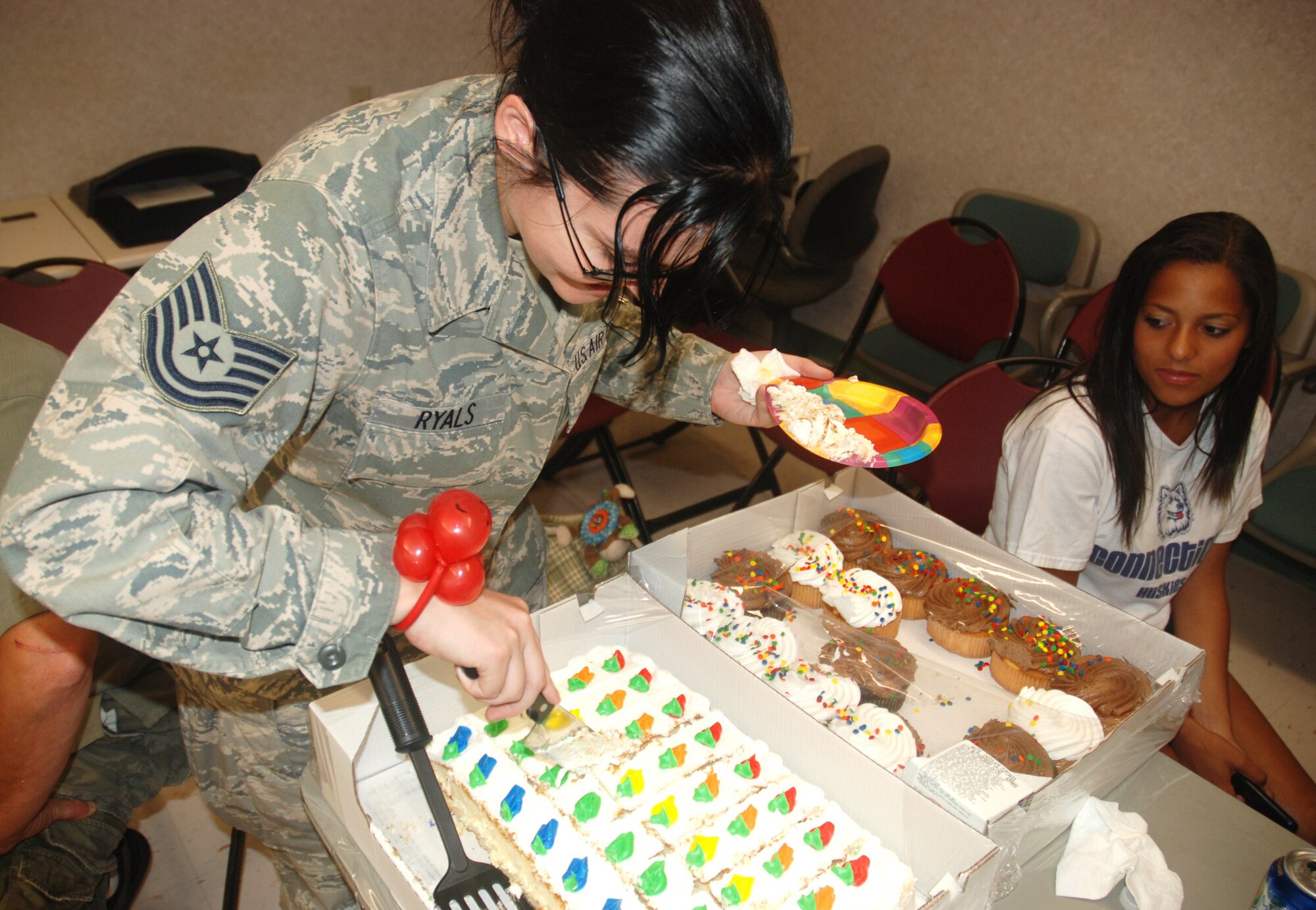 The 42nd Aerial Port Squardon held a family event at Westover on Sunday, August 8, for the families of deployed aerial porters. Technical Sgt. Amber Ryals cuts a cake for family members of aerial port squardon members who are currently deployed. 