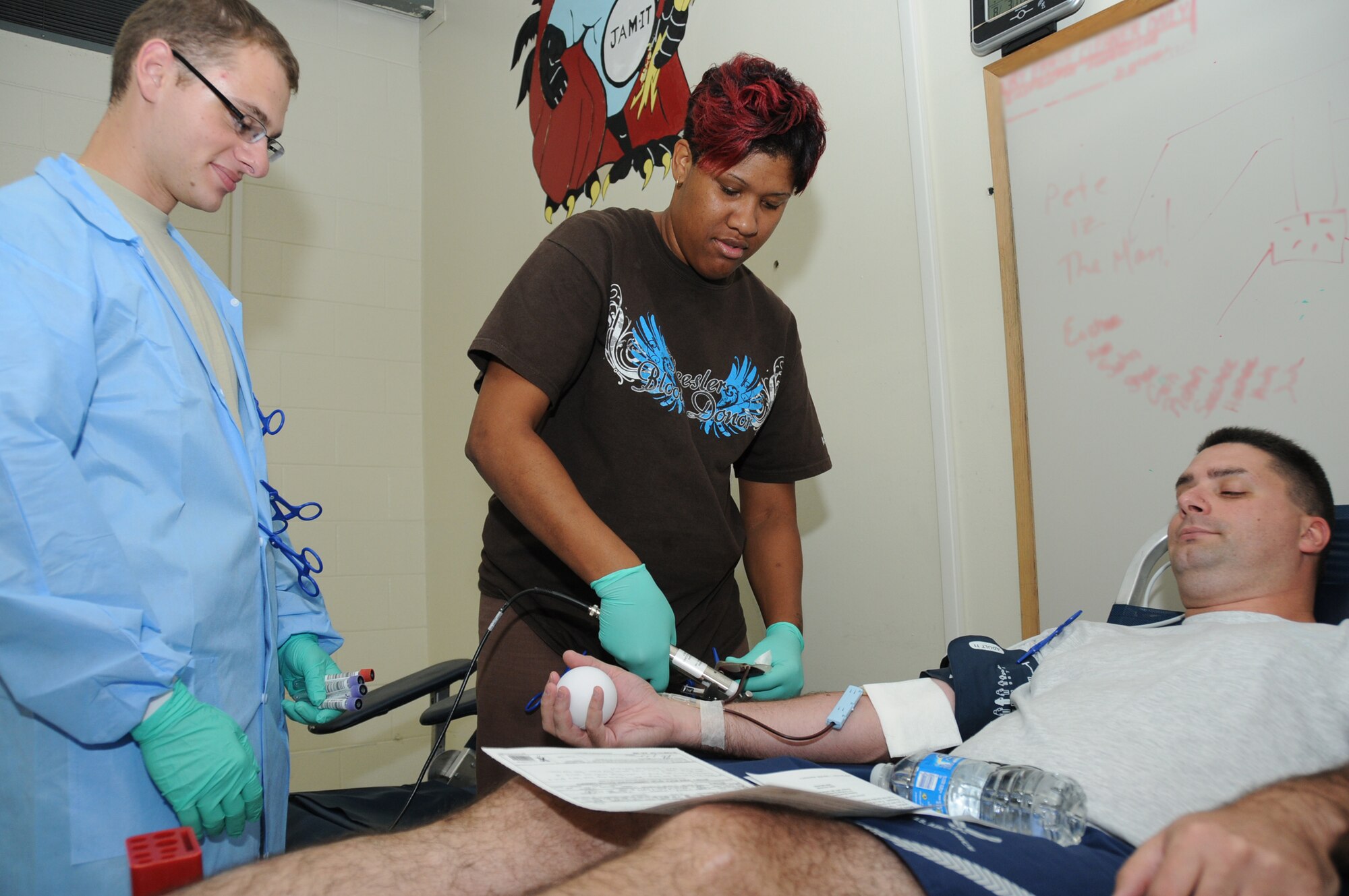 From left, Airman 1st Class Andriy Odayskyy collects tubes of blood as lab technician Kellie Potts draws a pint of blood from Staff Sgt. Peter Dunn, 338th Training Squadron instructor, during a blood drive at Hewes Hall Aug. 3.  Airman Odayskyy and Ms. Potts are from the 81st MDTS.  (U.S. Air Force photo by Kemberly Groue)