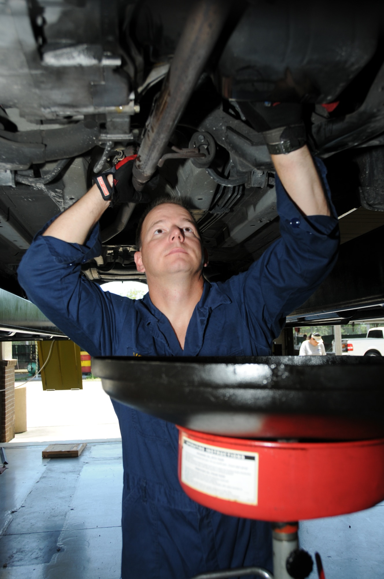 Chief Petty Officer Joel McEwen changes his oil at the auto hobby shop July 28.  The chief is assigned to the Supervisor of Shipbuilding in Pascagoula, Miss.  (U.S. Air Force photo by Kemberly Groue)