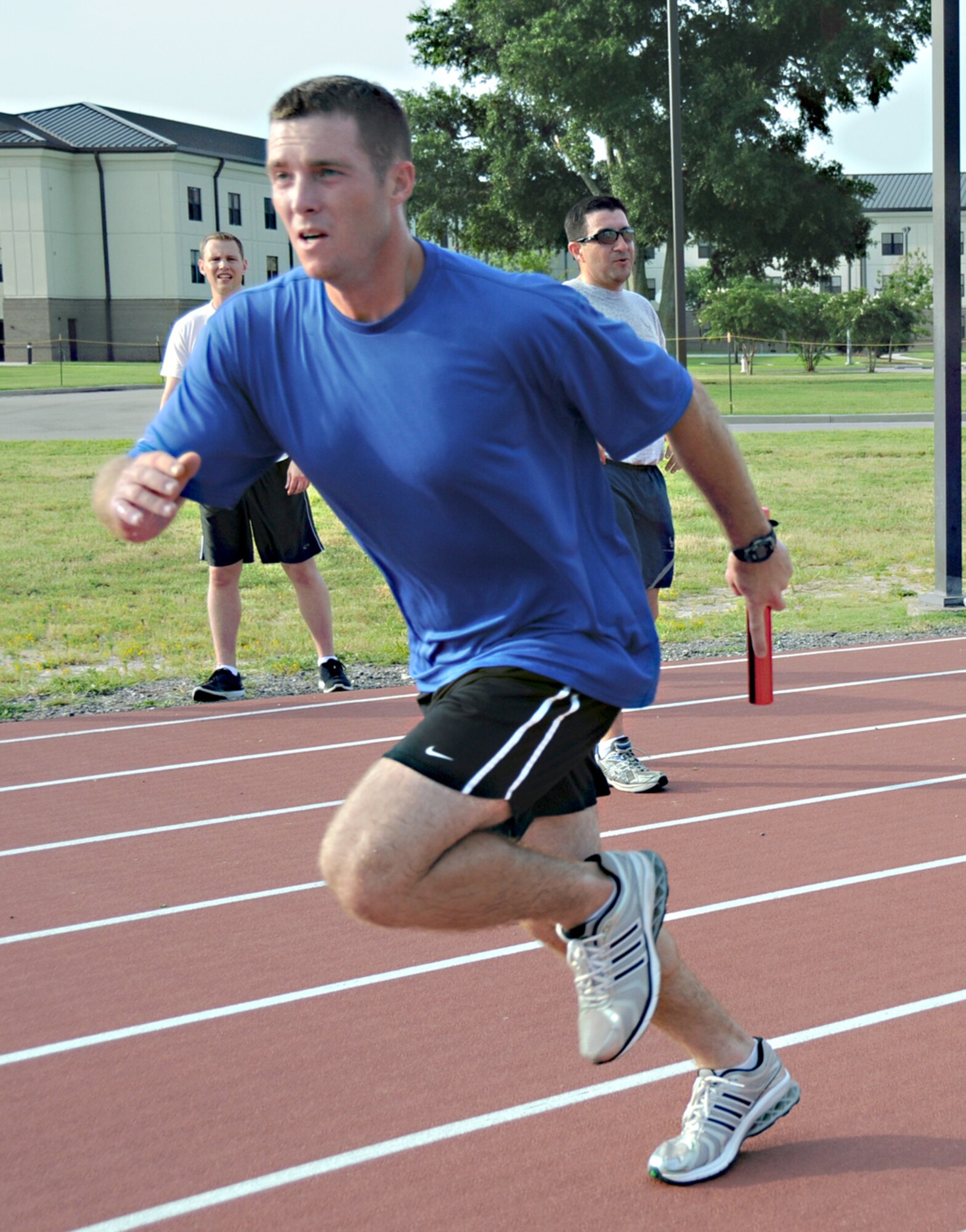 Cody Spitler, protocol office, takes his turn around the Triangle Track during Saturday’s Dog Day Baton Relay.  Six four-member teams ran the 20-mile race in ¼-mile segments.  The winning team included Spitler and Guillermo Hernandez, Mark Bautista and Dominic Ancona from the 81st Medical Operations Squadron.   (U.S. Air Force photo by Kemberly Groue)
