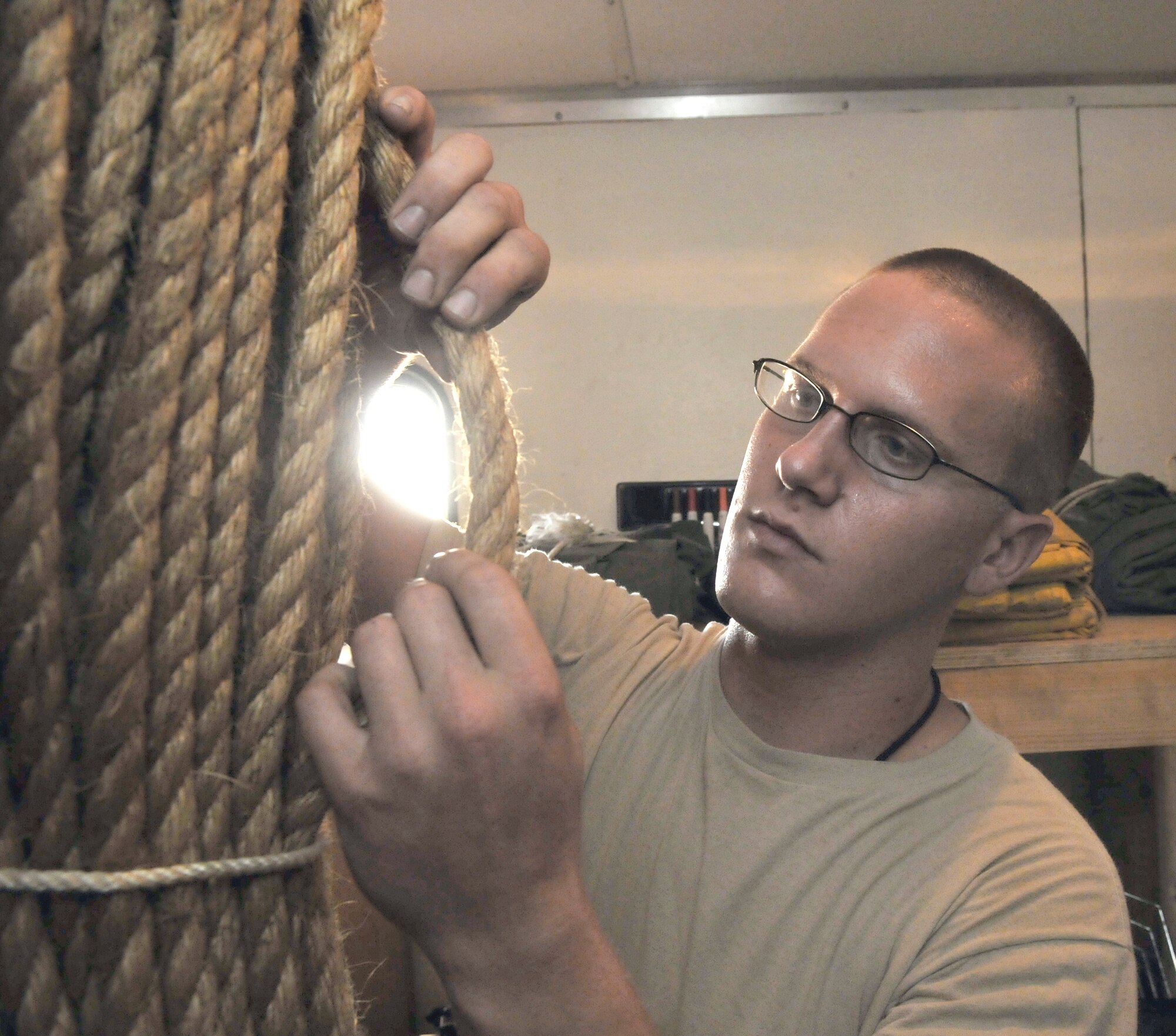 Senior Airman William Davenport inspects rope for serviceability July 9, 2010, at Joint Base Balad, Iraq. Rope is used as guidelines when hoisting and moving damaged aircraft from the airfield. Airmen Davenport is a 332 Expeditionary Maintenance Squadron crash recovery, wheel and tire technician. (U.S. Air Force photo/Staff Sgt. Phillip Butterfield)