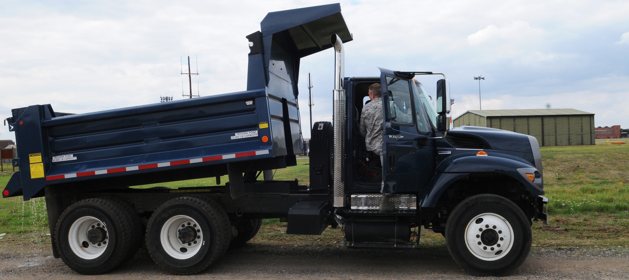 RAF MILDENHALL, England -- Col. Chad Manske, 100th Air Refueling Wing commander, lifts the bed of a 10-ton dump truck at the fire department's live-fire training area Aug. 11. Airmen from the 100th Civil Engineer Squadron showed the colonel the heavy machinery they use on a daily basis and the skill required to do so efficiently. Experiences like this give leaders a better understanding of their subordinates abilities. (U.S. Air Force photo/Staff Sgt. Thomas Trower) 