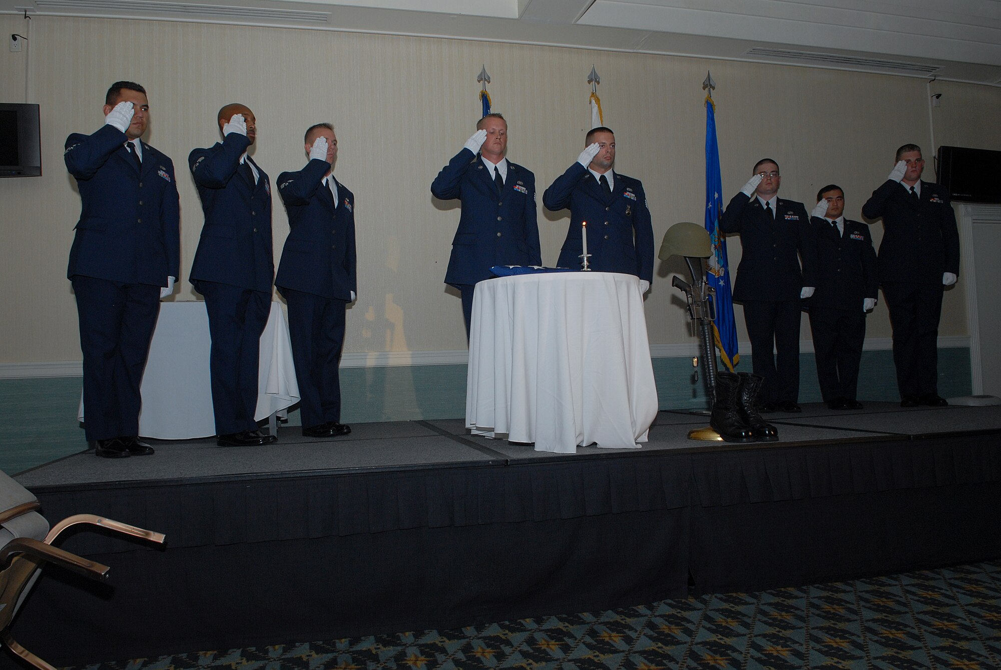 KUNSAN AIR BASE, Republic of Korea -- Members of the Kunsan Airman Leadership Class 10-K honor guard salute the flag placed at the Prisoner of War/Missing In Action table during the ALS Class 10-K graduation here Aug. 6. The class was the first at Kunsan in six years. (U.S. Air Force photo/Senior Airman Roy Lynch)