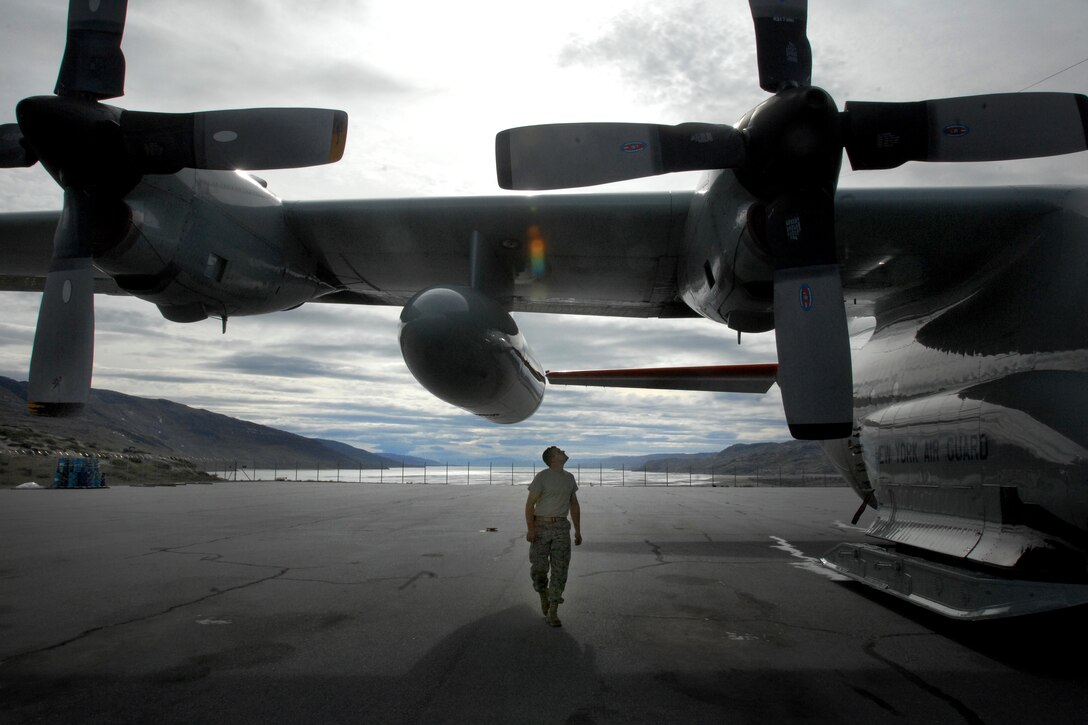 U.S. Air Force Staff Sgt. Kevin Byrns walks around the ski-equipped LC-130 Hercules cargo planes following a mission to one of the remote science outposts in Greenland,
July 29, 2010. Byrns, a crew chief is assigned to the 109th Airlift Wing of the New York Air National Guard.