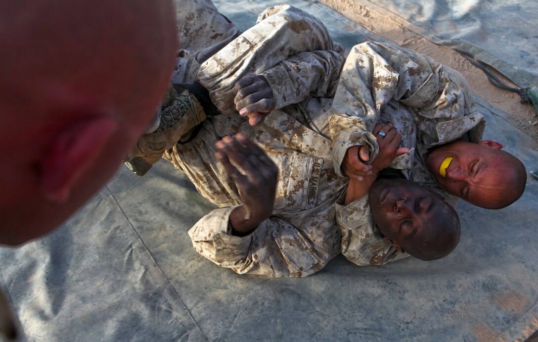 Master Sgt. Adrian Sena, the operations chief for 3rd Marine Aircraft Wing (Forward), right, tries to get a rear choke on Master Gunnery Sgt. Brad Brock, the communications chief for Marine Air Support Squadron 3, 3rd MAW (FWD), during a Marine Corps Martial Arts Program brown-belt class. Marines in the class each fought three, one-minute bouts. This part of the training allows the Marines to practice MCMAP techniques and learn how to fight while fatigued.