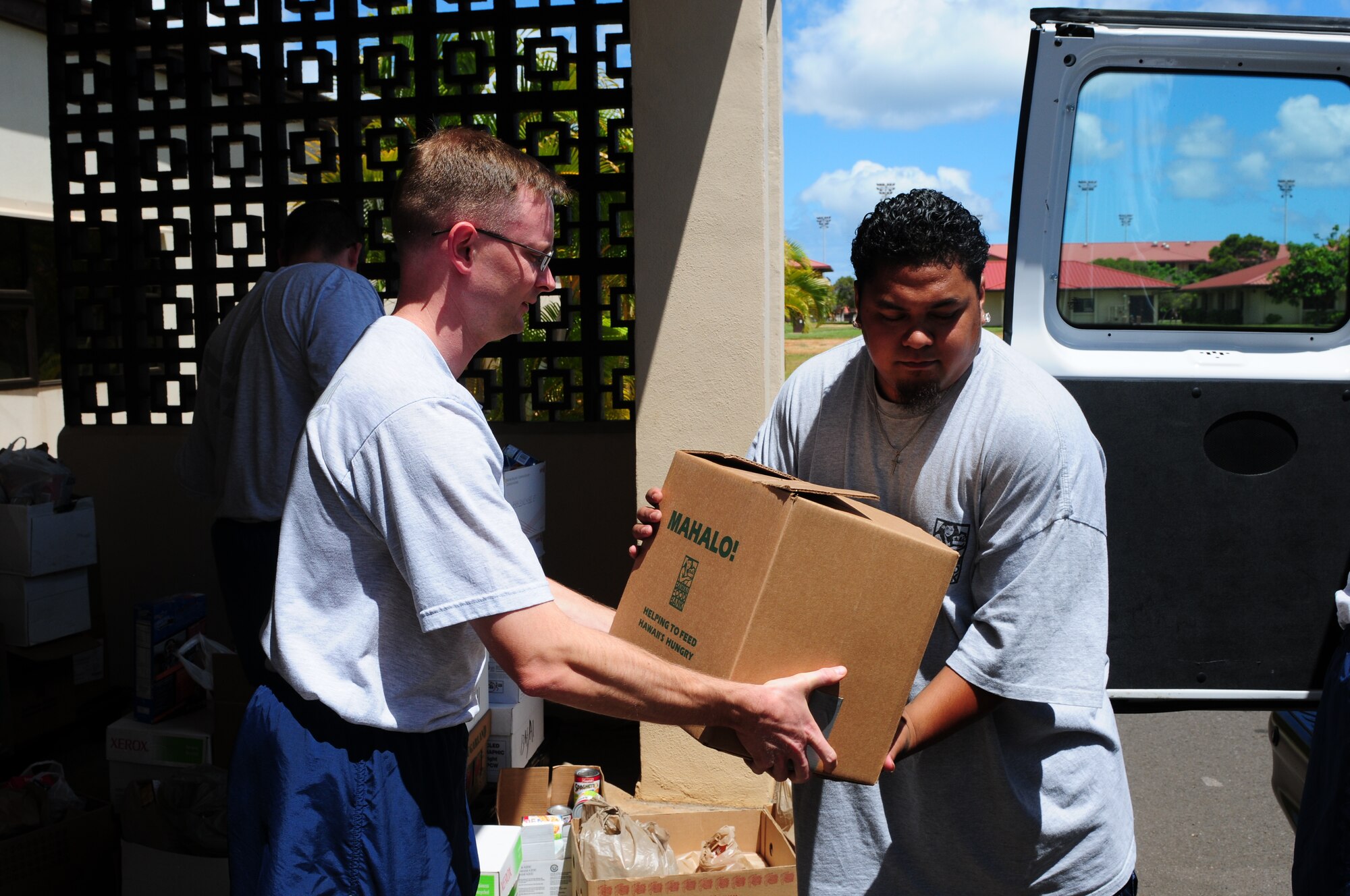 A representative from Hawaii Food Bank accepts donations from 13th Air Force jungle warriors at Joint Base Pearl Harbor Hickam, Hawaii, as part of Jungle Day on Aug. 13.  Thirteenth Air Force has observed Jungle Day in Hawaii since 2007, a tradition that originated when the organization was assigned to Andersen Air Force Base, Guam, because it gives members a chance to have fun and give back to the local community every Friday the 13th.(U.S. Air Force photos/ Master. Sgt. Victoria Meyer) 
 
