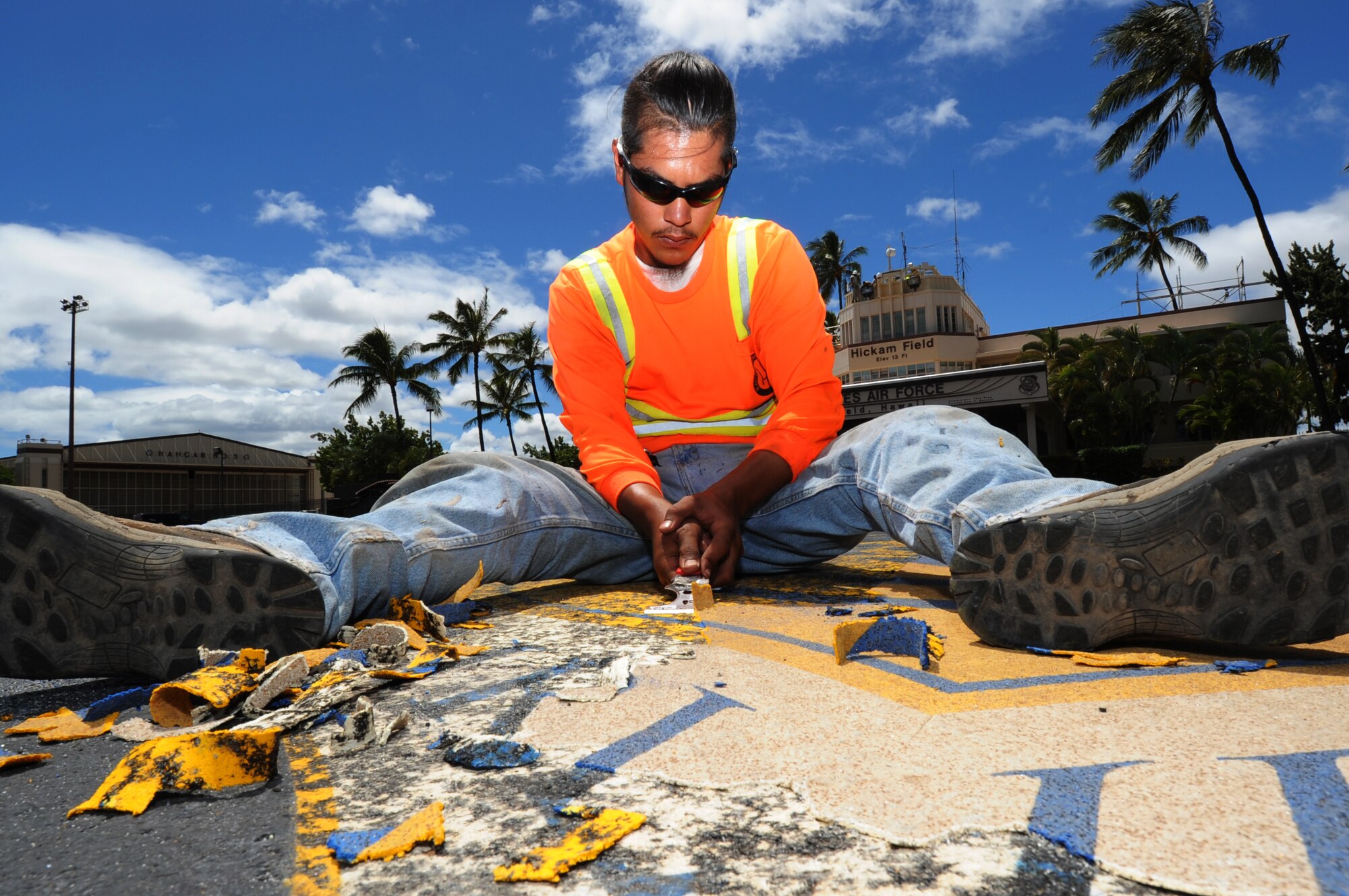 JOINT BASE PEARL HARBOR HICKAM, Hawaii - Cass Morris, a contractor from Maui, scrapes off the old 15th Airlift Wing patch from the flightline in front of Base Operations. The new 15th Wing patch will be displayed on the flightline in approximately one month. On May 18th ceremony, the 15th Airlift Wing was re-designed as the 15th Wing to accommodate the arrival of the F-22 and KC-135 units at Hickam. (U.S. Air Force photo by Staff Sgt. Nathan Allen) 