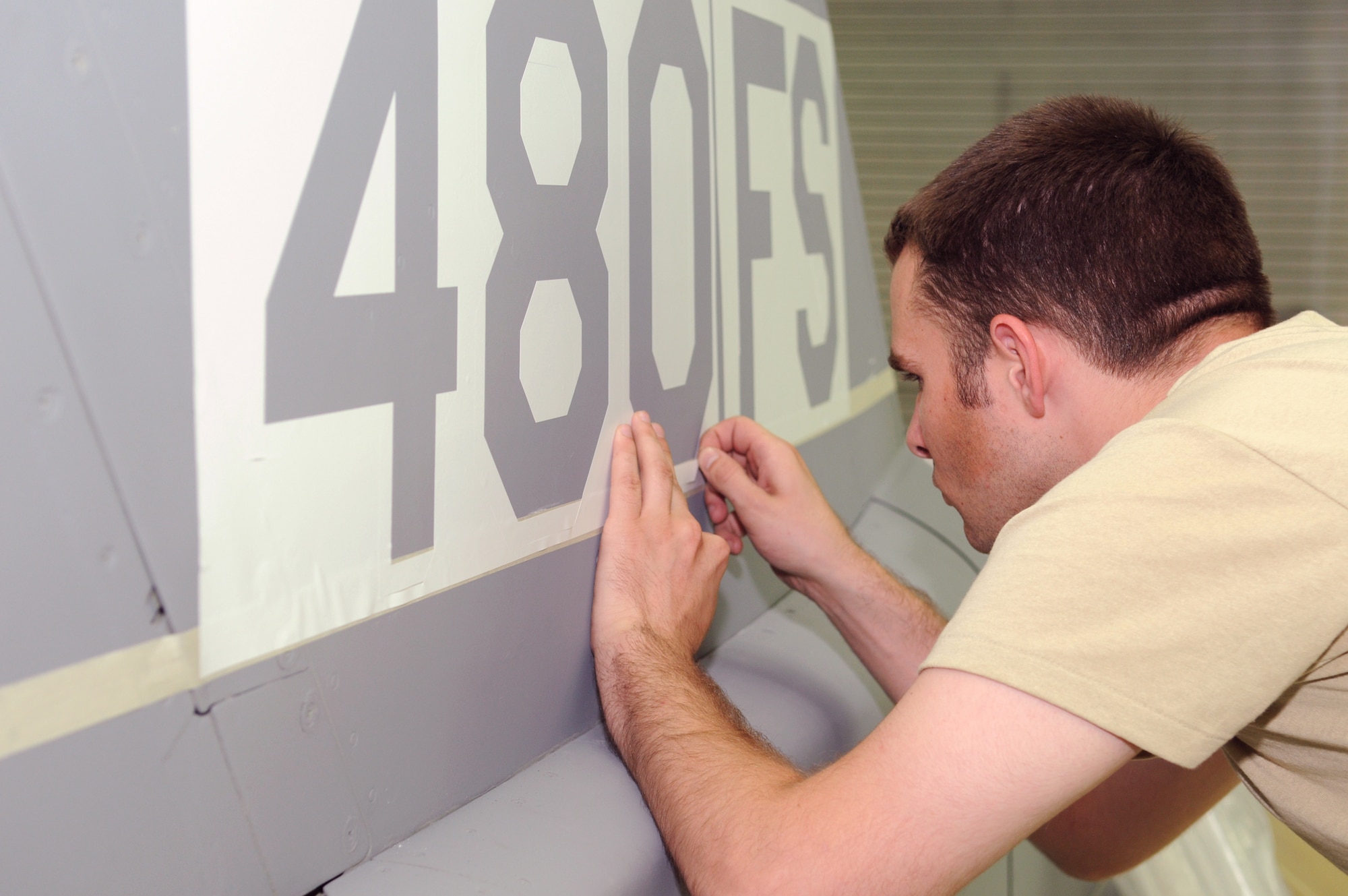 Senior Airman William Parker applies a stencil on a 480th Fighter Squadron F-16 Fighting Falcon Aug 8, 2010, at Spangdahlem Air Base, Germany. Airman Parker is a 52nd Equipment Maintenance Squadron aircraft structural maintenance journeyman. (U.S. Air Force photo/Staff Sgt. Benjamin Wilson) 
