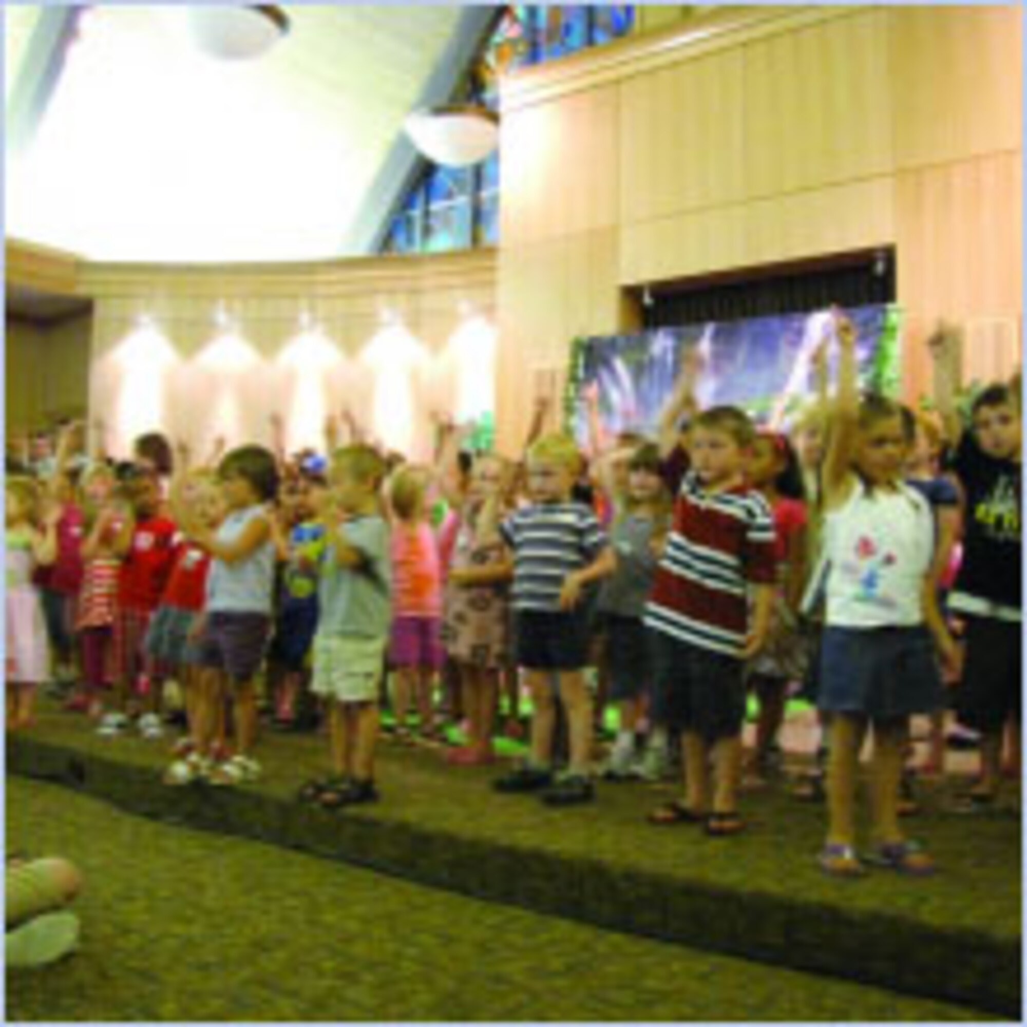 Preschool age participants of the Base Chapel's VBS concert, held in the main congregation area, sing and dance for the sudience. (Air Force photo by Lee Anne Hensley)