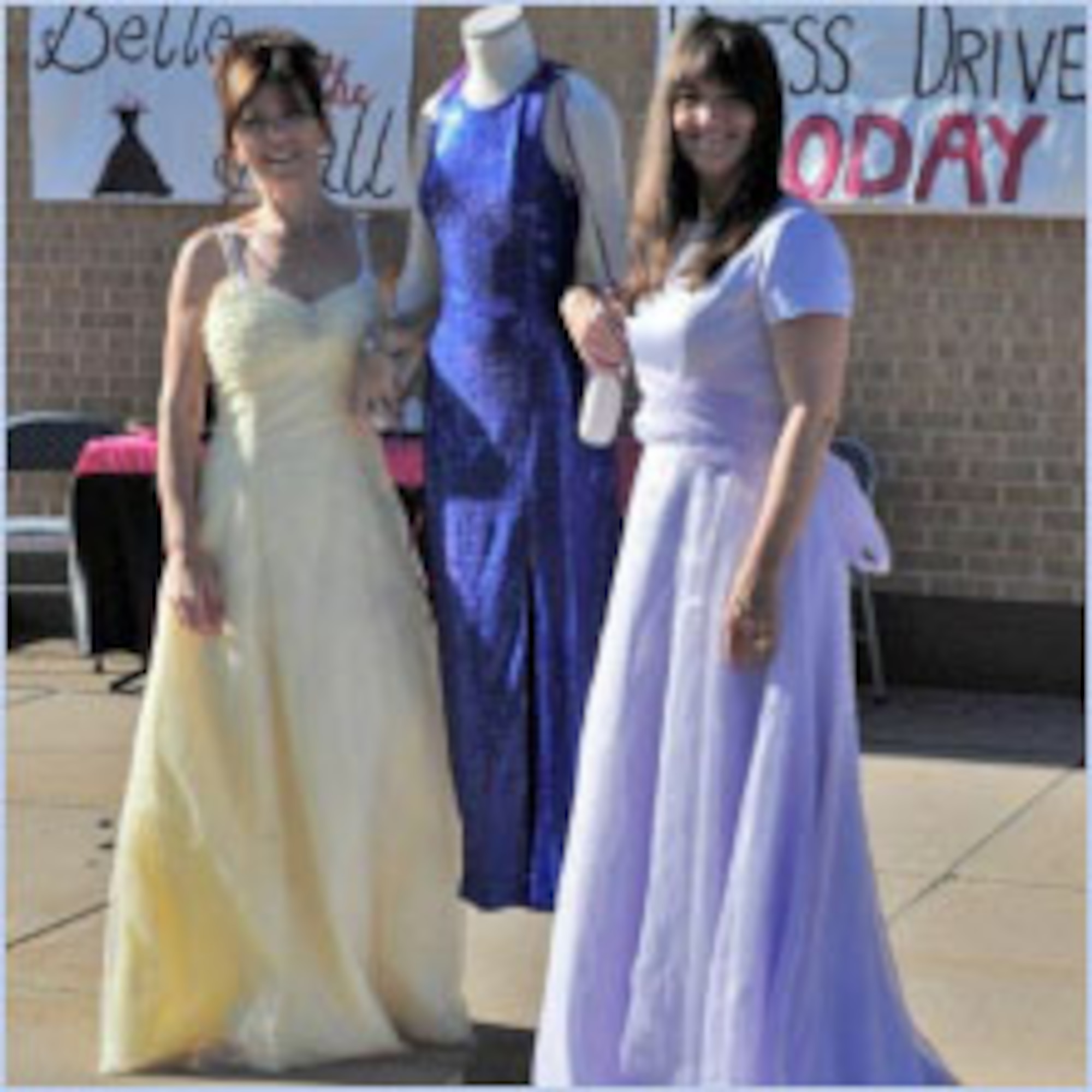 Kay Zobrist (left), spouse of 388th Fighter Wing Commander Col. Scott Zobrist, and Heather Higby, spouse of 75th Air Base Wing Commander Col. Patrick Higby, wear dresses collected for the Belle of the Ball Dress Program. Both women were co-organizers of the event. (Air Force photo by Kim Cook)