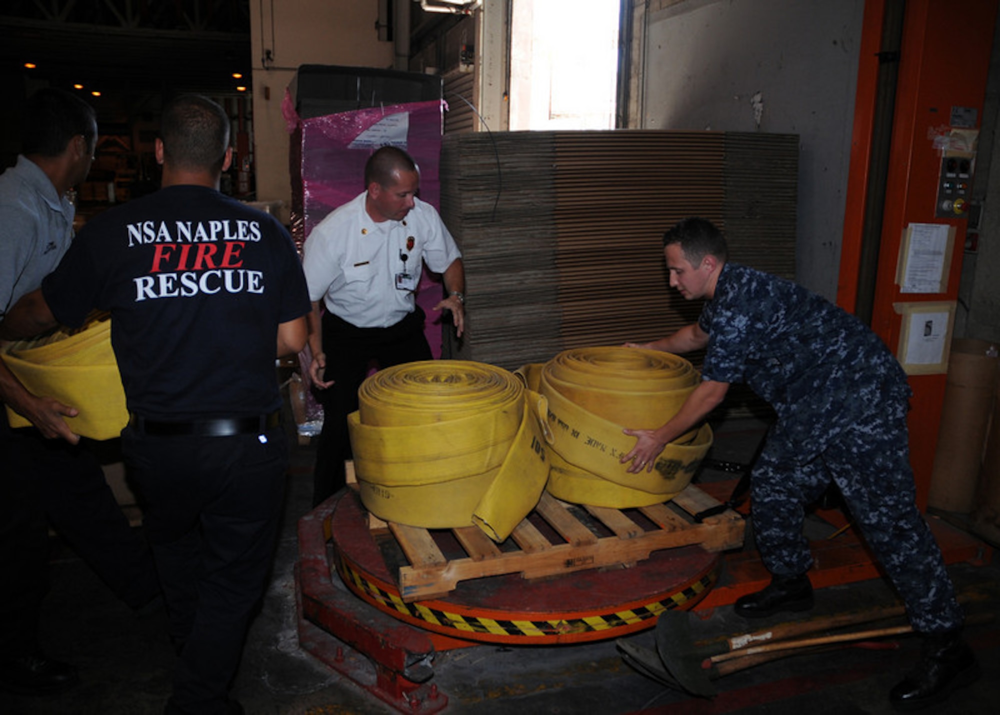 NAPLES, Italy -- Logistic Specialist 2nd Class(SW) Vitali Toptchenko, NSA Naples Lead Fire Inspector Hanz Christian, and Italian national firefighters Maurazio Patrone and Alessio Storto load a pallet of firefighting equipment destined for Russia to help combat wildfires  Aug.11, 2010. The U.S. Navy routinely provides foreign humanitarian assistance in times of crisis, in the same manner as many nations around the world. (U.S. Navy photo by Mass Communication Specialist 3rd Class Kristopher Regan)
