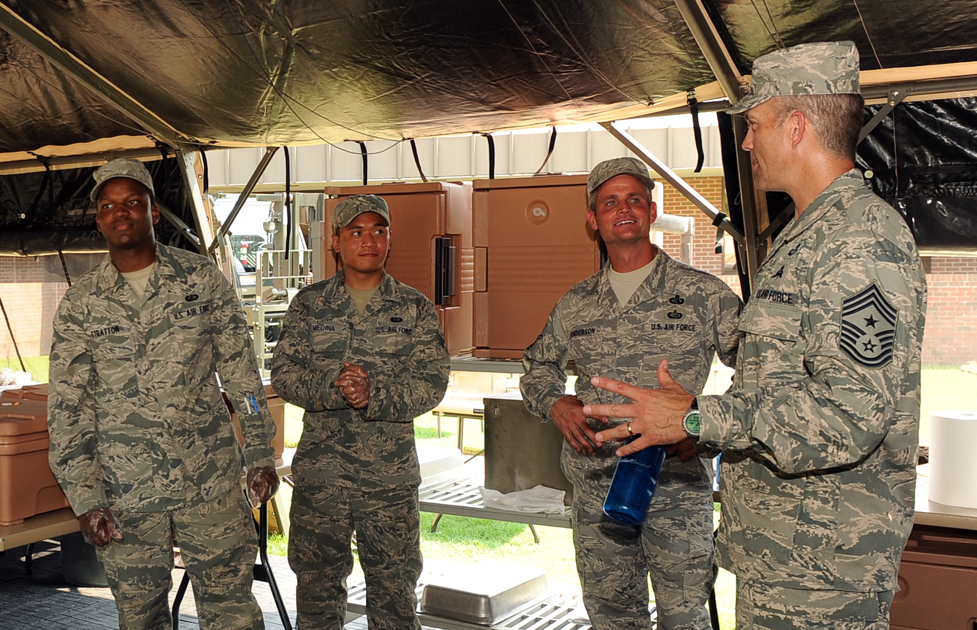 LANGLEY AIR FORCE BASE, Va. - Chief Master Sgt. Martin Klukas, Air Combat Command command chief, and Chief Master Sgt. Charles Anderson, 633d Air Base Wing command chief, talk to Senior Airman Ghil Medina, 633d Force Support Squadron food service journeyman, and Airman 1st Class Emanuel Stratton, 633 FSS fitness specialist, during a base tour Aug 10. Chief Klukas toured the base Aug. 9 and 10, interacting with Airmen from all squadrons to better understand their workforce and needs. (U.S. Air Force photo/Senior Airman Gul Crockett)

