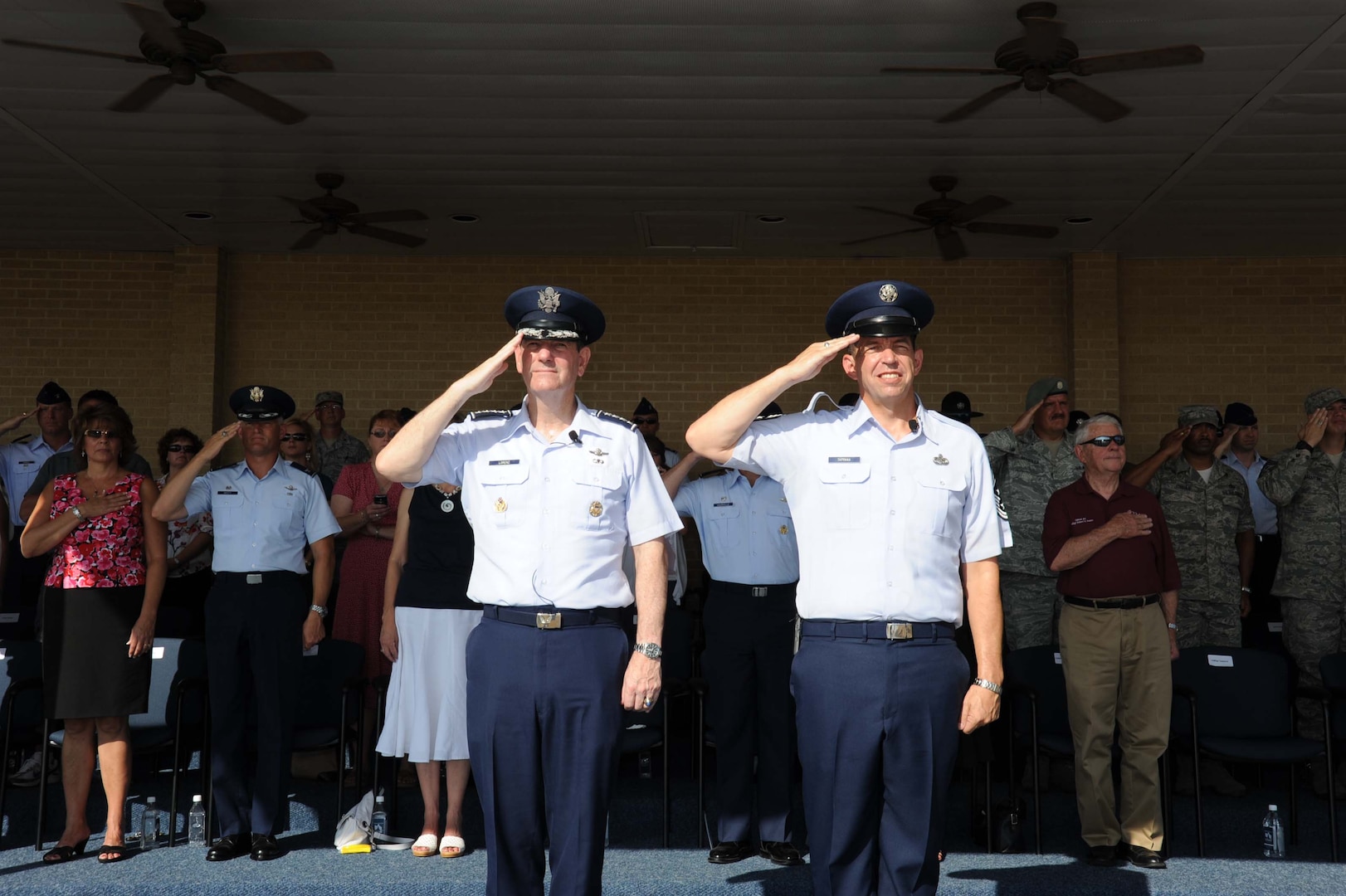 Gen. Stephen Lorenz (left), AETC commander and Chief Master Sgt. Robert Tappana (right), AETC command chief, salute during the national anthem during basic military training graduation at Lackland AFB, Texas Aug. 13.  This was chief’s last ceremony as he retired Aug 13 at Randolph AFB, TX. (U.S. Air Force photo/Alan Boedeker)