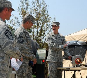 LANGLEY AIR FORCE BASE, Va. - Tech. Sgt. Ryan Hill, 633d Force Support Squadron unit deployment manager, shows Chief Master Sgt. Martin Klukas, Air Combat Command command chief, and Chief Master Sgt. Charles Anderson, 633d Air Base Wing command chief, the Babington Airtronic Burner for the Single Pallet Expeditionary Kitchen during base tour Aug 10.  SPEK is a lightweight quick response kitchen capable of serving 550 personnel. It is best used in austere locations for up to 30 days. (U.S. Air Force photo/Senior Airman Gul Crockett) 