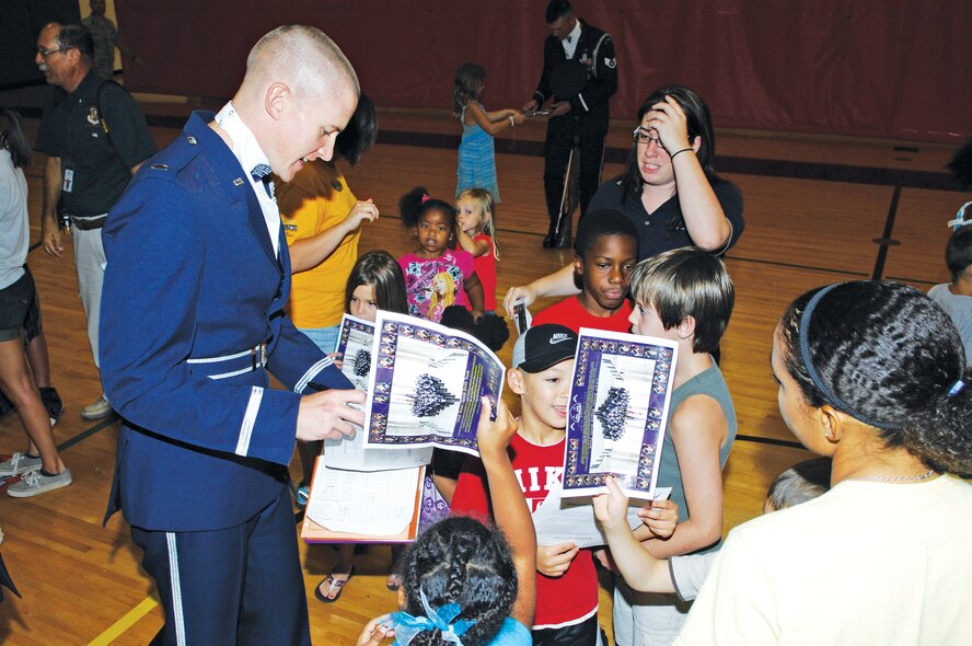 1st Lt. Chad Frey from the Air Force Honor Guard Drill Team signs autographs for children after the team's performance held on August 10 at the Luke Youth Center, Luke Air Force Base, Arizona.  (U.S. Air Force photo/Staff Sgt. Steve Nabor)