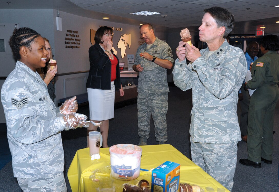 Senior Airman Tiffany Miles, Air Force District Washington knowledge operator, serves ice cream to Maj. Gen. Darrell D. Jones, AFDW commander, during a Lemonade Sip/Ice Cream Dip Social held inside the 316th Wing headquarters building atrium Wednesday. Sponsored the Andrews Chaplains, the purpose of the event was to provide a social meeting atmosphere for military and civilian members assigned to Joint Base Andrews. (U.S. Air Force photo/ Bobby Jones)