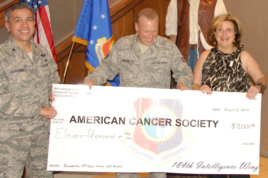 The 184th Intelligence Wing hosted its annual Lyle Houghton Cancer Benefit Golf Tournament July 11 at Hidden Lakes Golf Course, raising $11,000 for the American Cancer Society. 
Elizabeth Cord of the American Cancer Society first learned the amount of the donation at the time of this photo, taken Aug. 11. She said the proceeds will help cancer patients with transportation costs as they travel to treatment.
