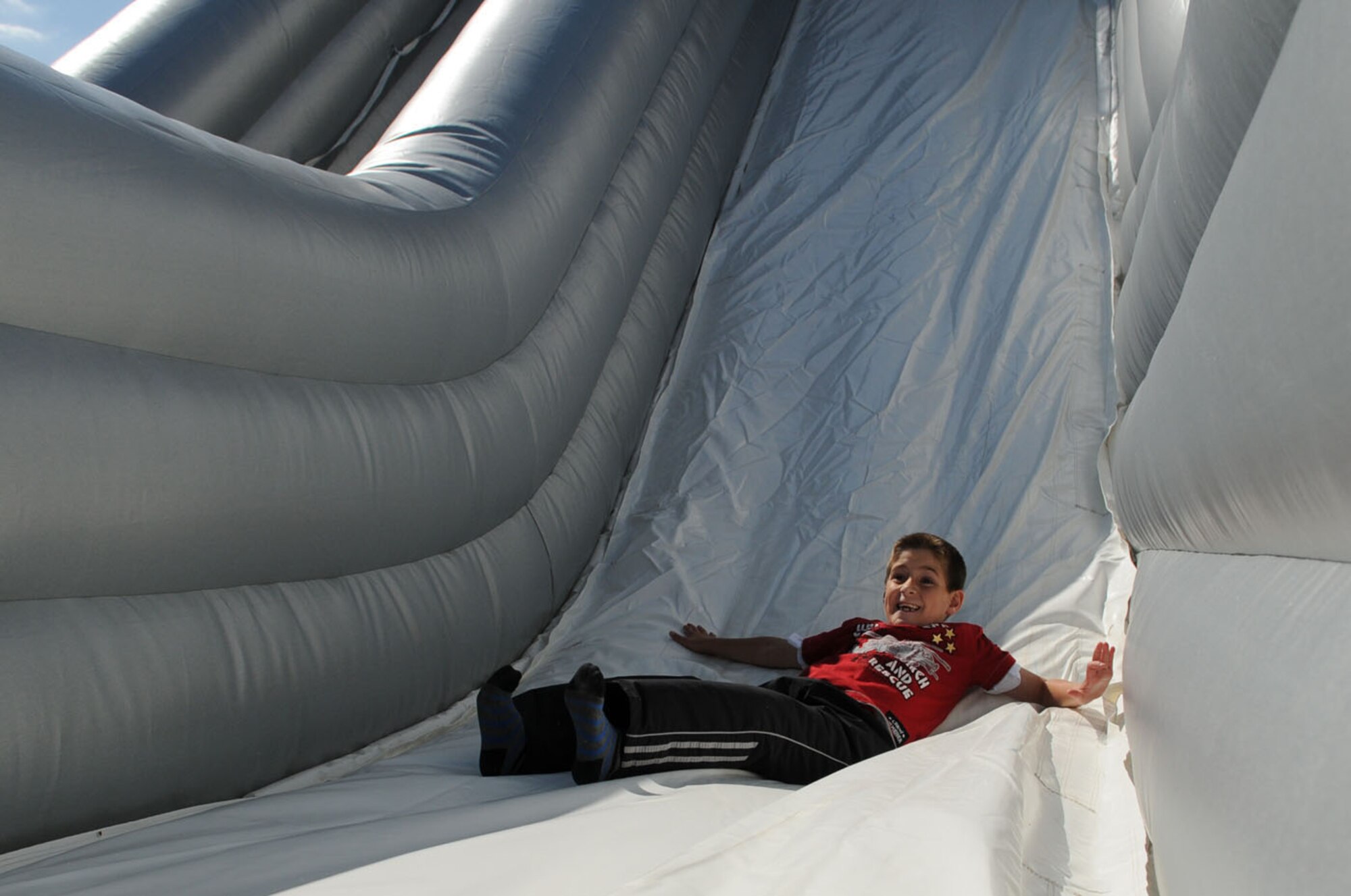 RAF MILDENHALL, Engalnd -- Adrian Hylton, 8, has fun as he goes down the inflatable slide Aug. 9 at the fire prevention event at the youth center. (U.S. Air Force photo/Karen Abeyasekere)