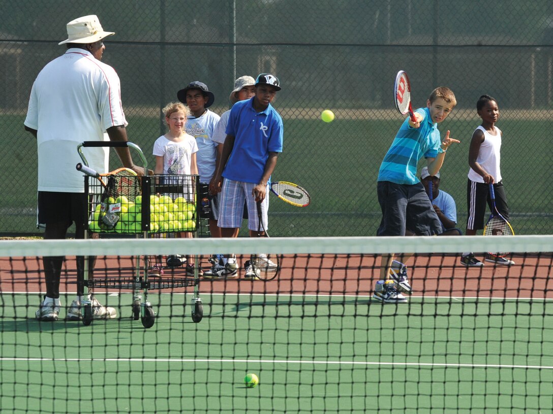 Assistant coach John Petway, left, U.S. Professional Tennis Registry, and other participants observe as Stephen Gralewsky, 13, right, performs a backhand stroke during the Second Annual Tennis Camp on the tennis courts near the West Fitness Center Wednesday. The Youth Center hosted the free week-long camp which was funded by The Year of the Air Force Family. Approximately 29 children, ages, 9 to 16, were taught the tennis fundamentals of the backhand, forehand and volleys. The tennis camp ends today.  (U.S. Air Force photo/ Bobby Jones)