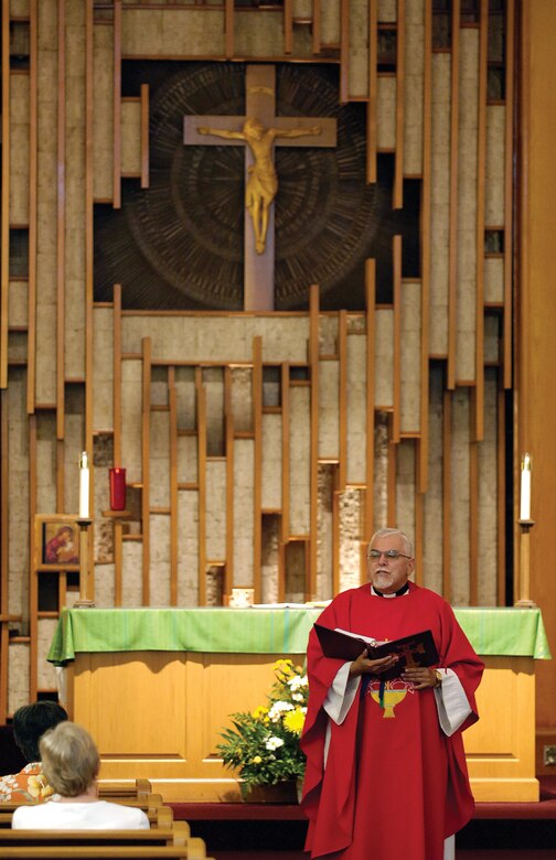 Daily Mass offers base Catholics a mid-day spiritual uplift.  Leading the service Aug. 10, Father Manuel Magallanes wears a red vestment, signifying martyrs, during the Feast of St. Lawrence.  Father Magallanes is from St. Gregory’s Abbey in Shawnee and supports the Tinker Base Chapel Catholics by sharing service work with other Catholic chaplains. (Air Force photo by Margo Wright)