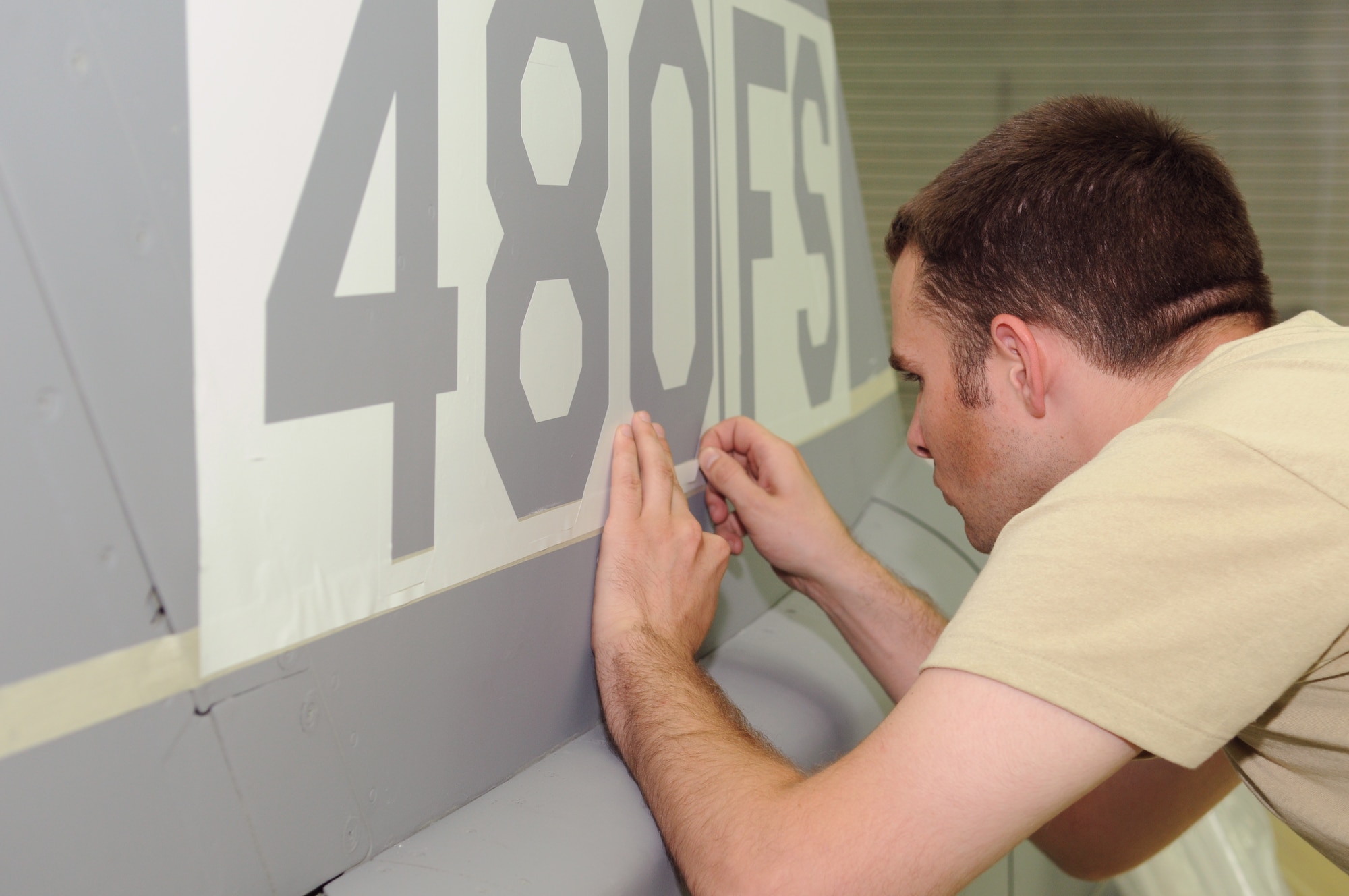 SPANGDAHLEM AIR BASE, Germany -- Senior Airman William Parker, 52nd Equipment Maintenance Squadron aircraft structural maintenance journeyman, applies a stencil on the 480th Fighter Squadron’s flag ship, an F-16 Fighting Falcon, Aug 8. The aircraft’s tail flash was painted in preparation for the reactivation of the 480th FS on Aug 13. (U.S. Air Force photo/Staff Sgt. Benjamin Wilson)