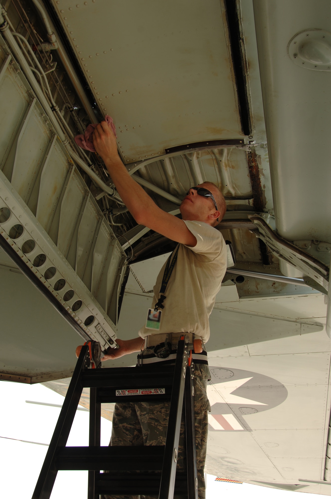 SOUTHWEST ASIA --  Staff Sgt. Brett Haberman, 379th Expeditionary Aircraft Maintenance Squadron, wipes hydraulic fluid from a RC-135 V/W Rivet Joint aircraft at an undisclosed location Aug. 9, 2010, after a mission. This mission marked 20 years of continuous operation in the U.S. Central Command's area of responsibility for the aircraft from Offutt Air Force Base, Neb. (U.S. Air Force photo/Tech. Sgt. Kimberly Spinner) RELEASED