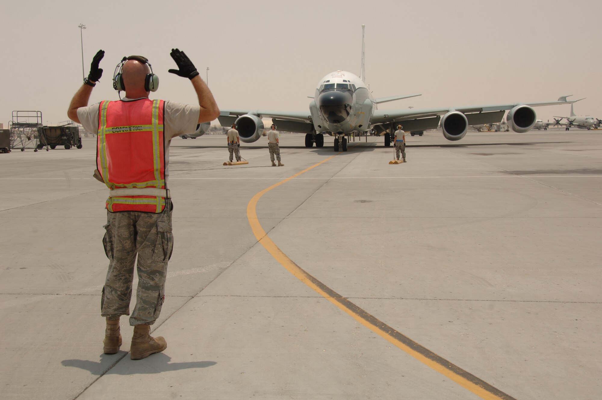SOUTHWEST ASIA -- Members of the 379th Expeditionary Aircraft Maintenance Squadron, marshal a RC-135 V/W Rivet Joint aircraft at an undisclosed location Aug. 9, 2010, after a mission. This mission marked 20 years of continuous operation in the U.S. Central Command's area of responsibility for the aircraft from Offutt Air Force Base, Neb. (U.S. Air Force photo/Tech. Sgt. Kimberly Spinner) RELEASED
