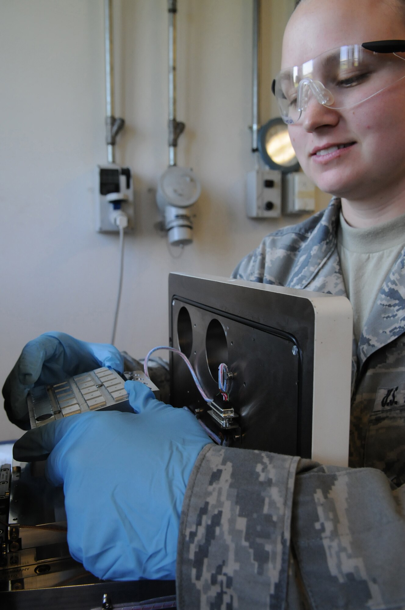 Senior Airmen Tonya Griggs, 31st Maintenance Squadron, Non Destructive Inspection technician, inserts a magnetic strip using the magnetic chip detector in search of wear and debris in the chip that are beyond normal levels, Aug 11.(U.S. Air Force photo/ Staff Sgt. Nadine Y. Barclay)