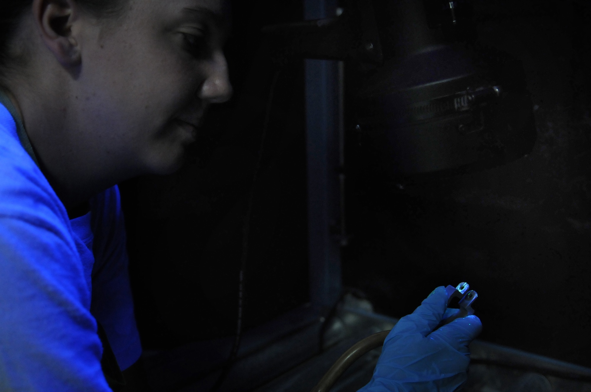 Airman 1st Class Tonya Tyson, 31st Maintenance Squadron, Non Destructive Inspection technician, inspects an F-16 Fighting Falcon ejection handle under a black light to search for defects that could prevent a pilot's safe ejection from the aircraft, Aug. 11.   (U.S. Air Force photo/ Staff Sgt. Nadine Y. Barclay)
