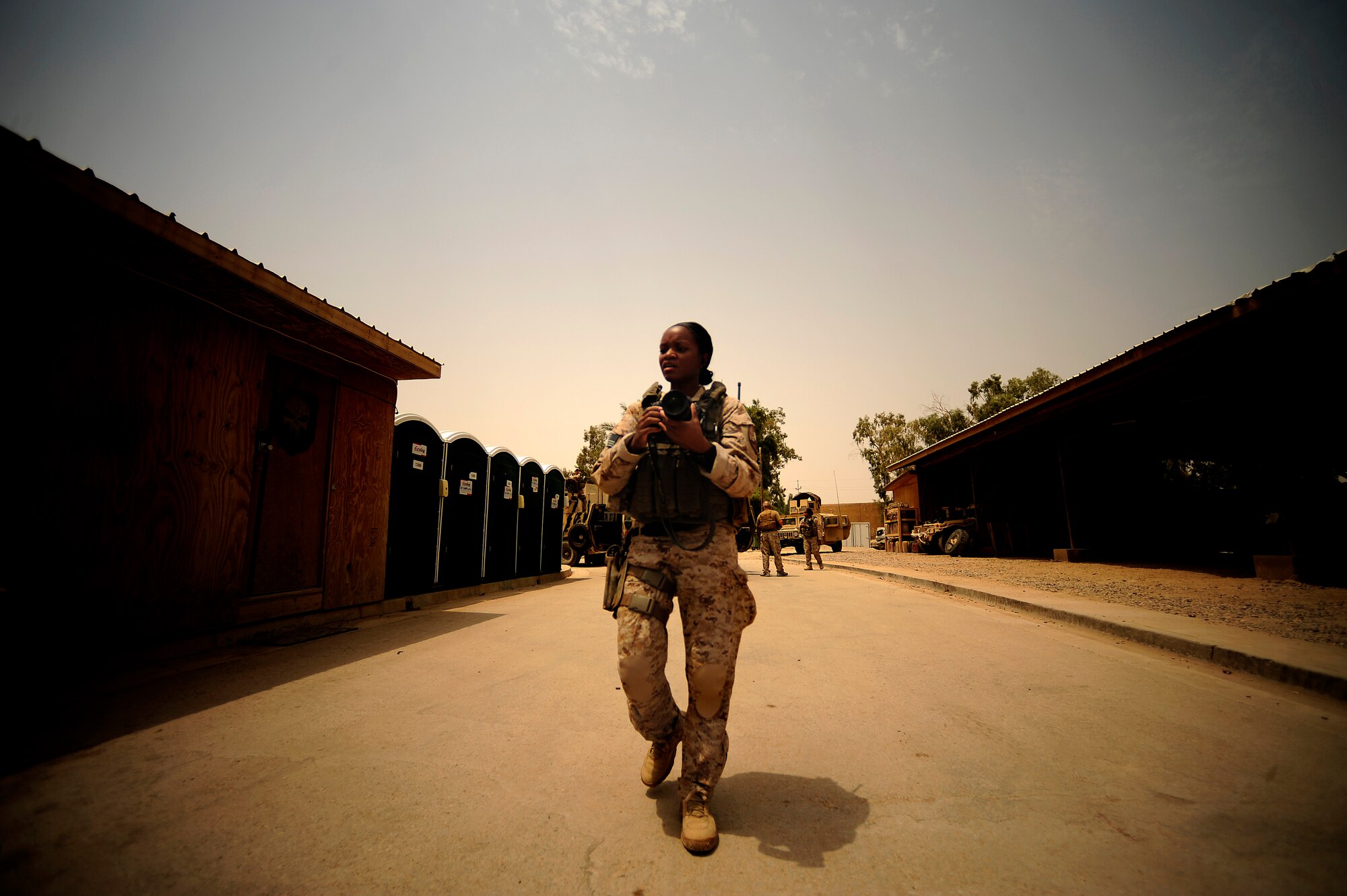 U.S. Air Force Senior Airman Asha McMakin, a combat photographer assigned to the 1st Combat Camera Squadron, walks over to take pictures of team members gearing up for key leader engagement mission out of Ramadi, Iraq on Aug. 2, 2010. SrA McMakin is attached to an Army Civil Affairs team while deployed in support of Operation Iraqi Freedom.
(U.S. Air Force photo by Staff Sgt. Andy M. Kin / Released)