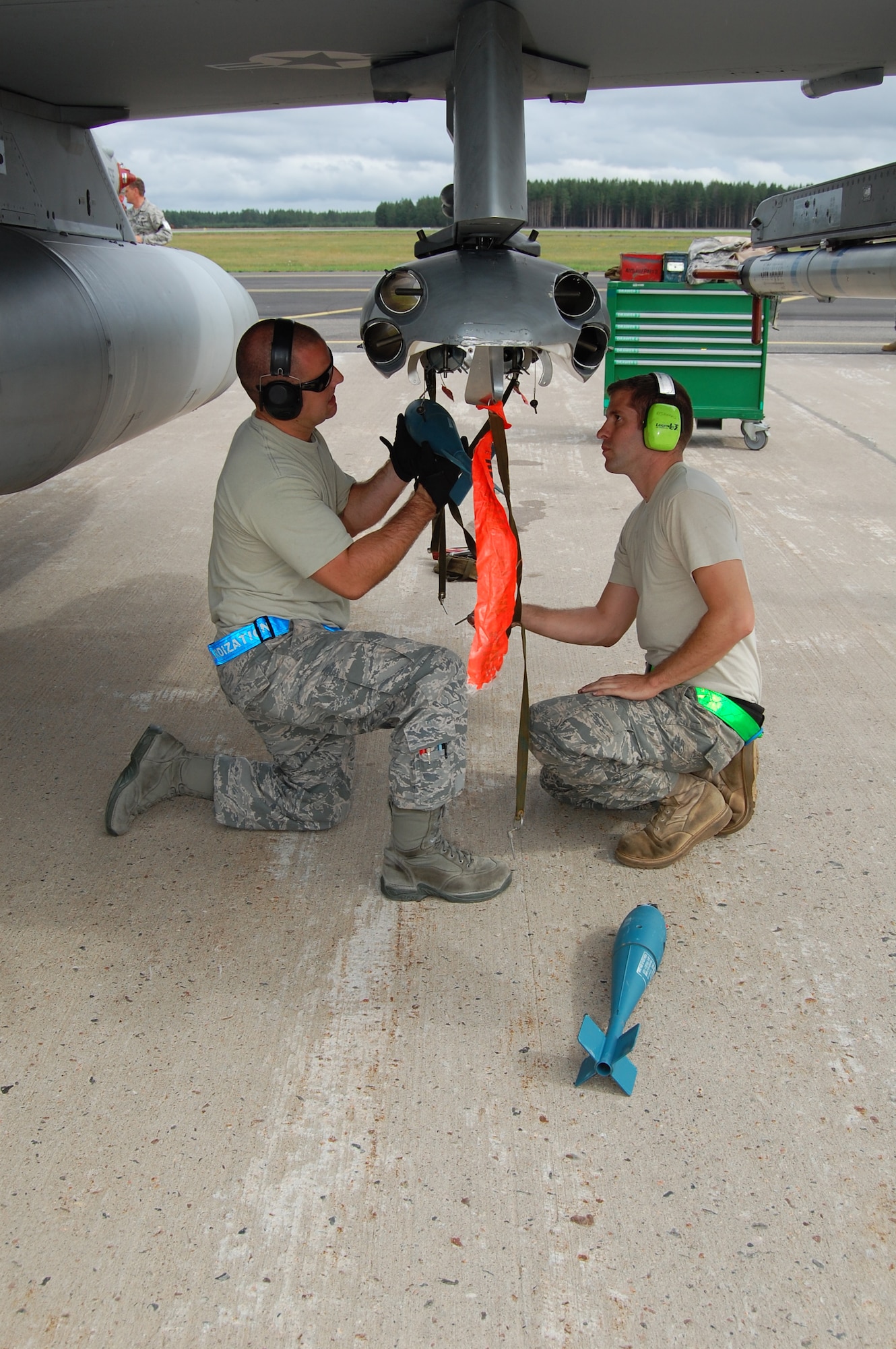 From left, Senior Airman James McAndrew, 31st Maintenance Operations Squadron weapons standardization, and Staff Sgt. John Tuscher, 31st Aircraft Maintenance Squadron weapons load crew member, load practice munitions onto an F-16 Aug. 5, 2010 at Kallax Air Base, Sweden. The 555th Fighter Squadron and 31st AMXS conducted more than 180 air-to-air and air-to-ground missions during a two week exercise at the air base in which they worked alongside the Swedish air force's Norrbotten Wing. (U.S. Air Force photo by Tech. Sgt. Lindsey Maurice/Released)
