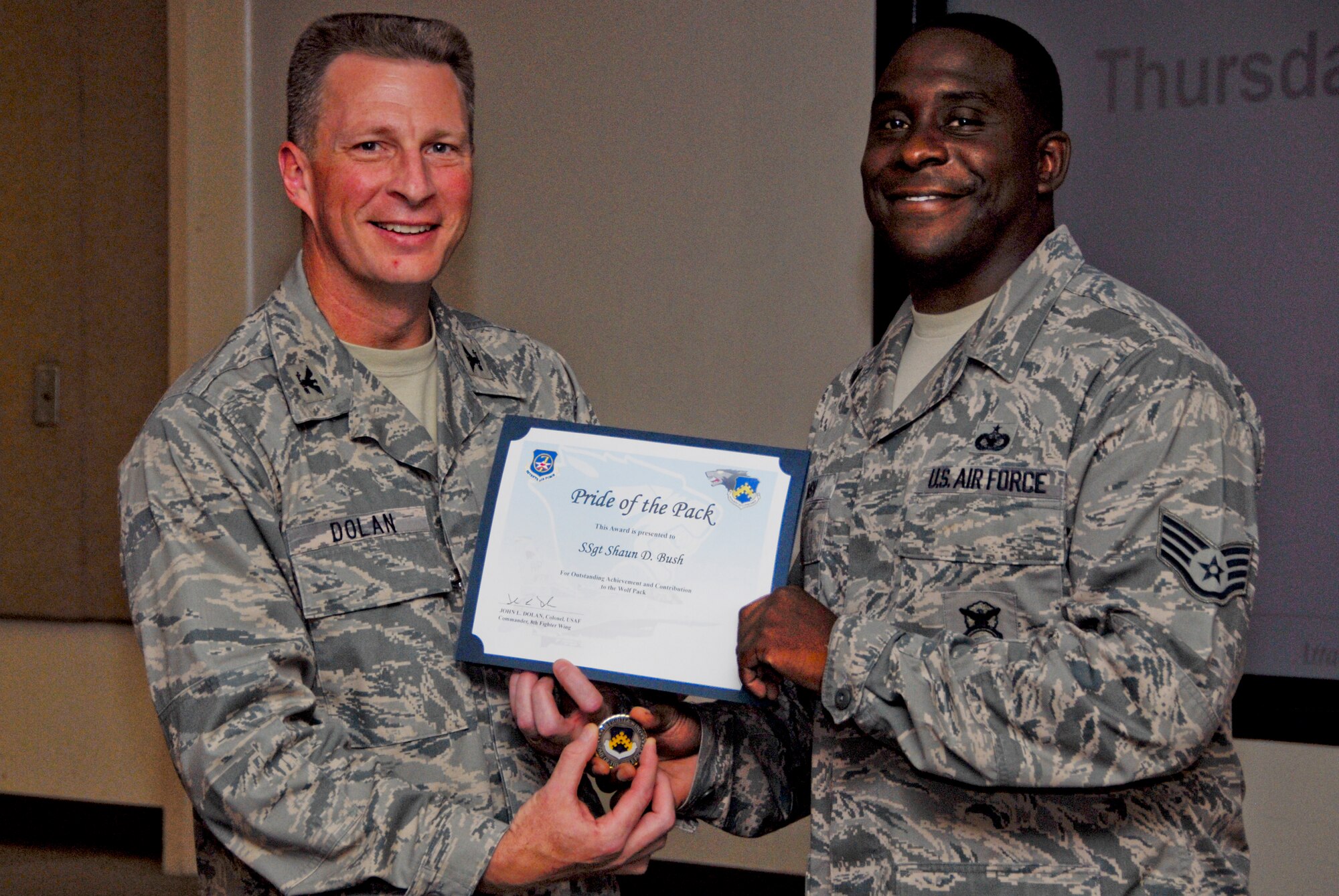 KUNSAN AIR BASE, Republic of Korea -- Col. John Dolan, 8th Fighter Wing commander, presents a Pride of the Pack award to Staff Sgt. Shaun Bush, 8th Security Forces Squadron, Aug. 12. (U.S. Air Force photo/Staff Sgt. Amanda Savannah)