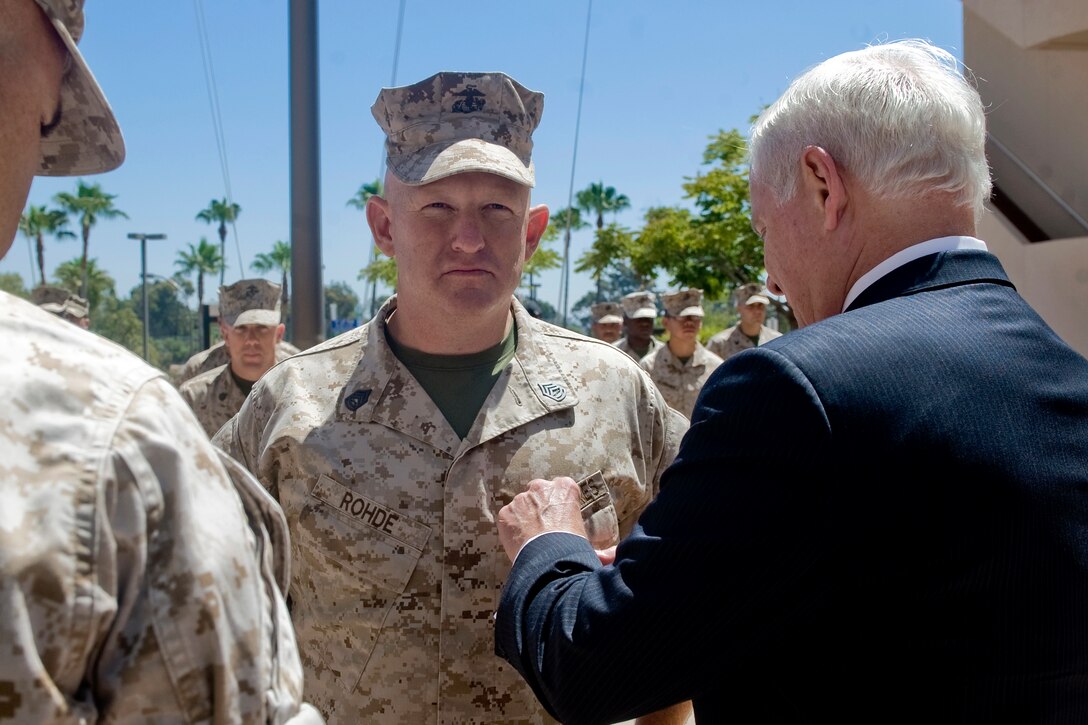 U.S. Defense Secretary Robert M. Gates presents the Purple Heart to U.S. Marine Corps Gunnery Sgt. David Rohde at Balboa Naval Hospital in San Diego, Aug. 12, 2010.
