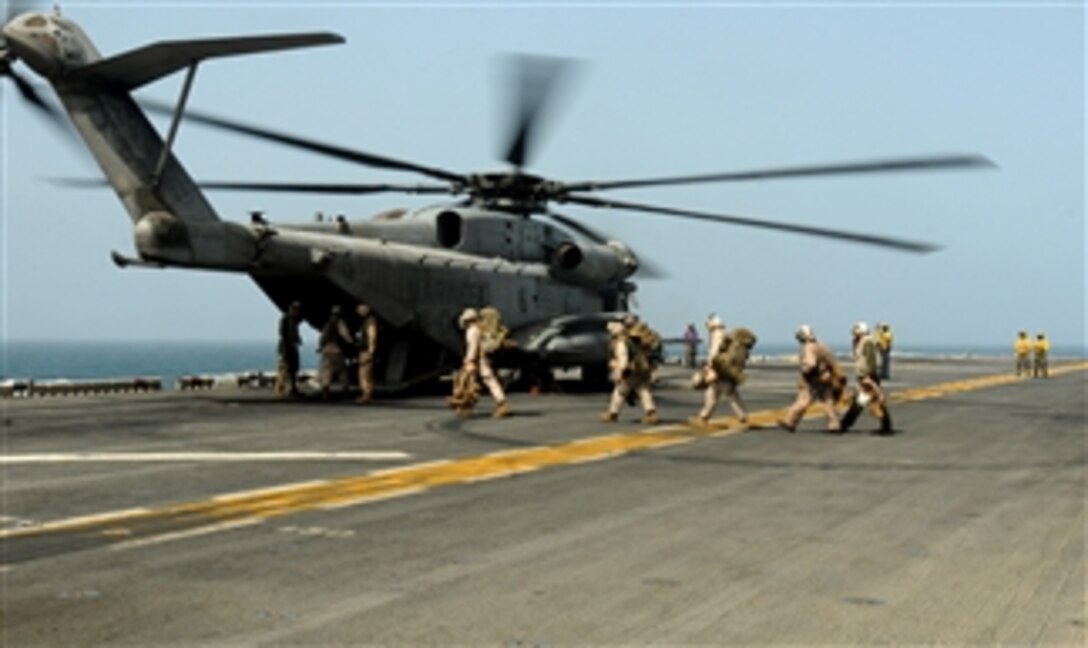 U.S. Marines prepare to board a CH-53E Super Stallion helicopter assigned to Helicopter Marine Medium Squadron 165 aboard the USS Peleliu (LHA 5) in the Arabian Sea to support those providing relief supplies to flooded areas of Pakistan on Aug. 12, 2010.  