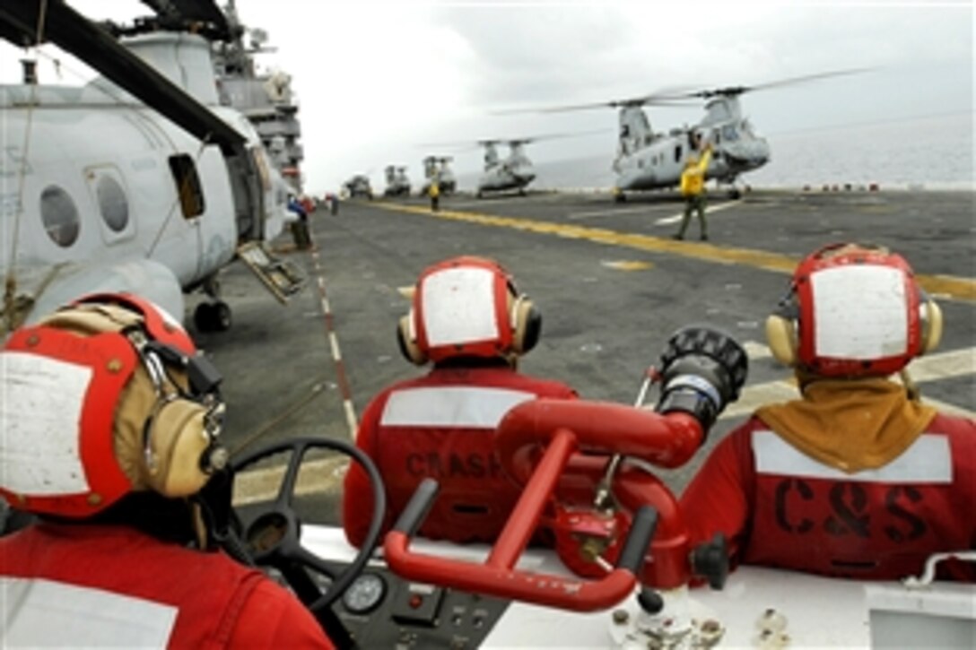 U.S. Navy sailors observe flight operations aboard the USS Peleliu as Marine Corps CH-46 Sea Knight helicopters prepare for take-off to provide aid to flood-stricken Pakistan, under way in the North Arabian Sea, Aug. 13, 2010. 