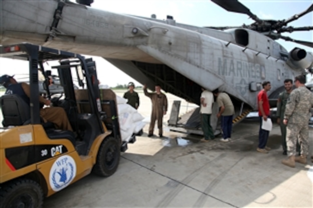 A forklift with bags of humanitarian assistance is loaded by Pakistani workers into a U.S. Marine Corps CH-53E Sea Stallion helicopter that has arrived to take over the flight role from the U.S. Army 3rd Combat Aviation Brigade, in the delivery of humanitarian assistance to the flood victims as part of the disaster recovery effort in Khyber Pakhtunkhwa province, Pakistan, Aug 13, 2010.
