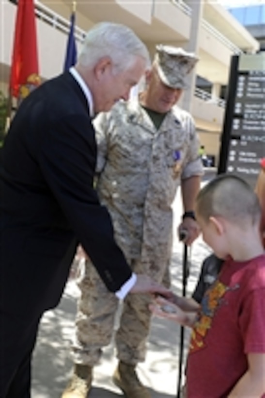 Secretary of Defense Robert M. Gates presents coins to the children of Purple Heart recipient Marine Gunnery Sgt. David Rohde at Balboa Naval Hospital in San Diego, Calif., on Aug. 12, 2010.  