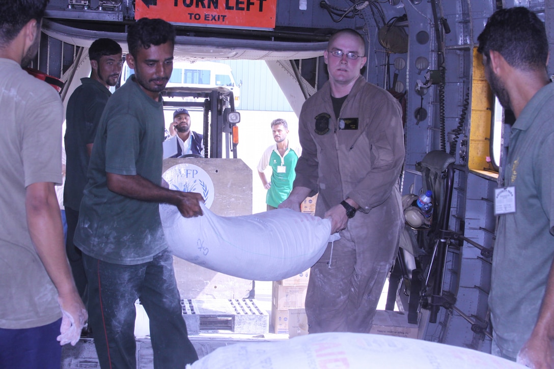 Cpl. Donald Cutler, a member of the HMM-165 reinforced (REIN), 15th Marine Expeditionary Unit assists local Pakistani citizens with loading food onto a Marine Super Stallion (CH-53E) as a part of humanitarian relief efforts in Pakistan, Khyber Pakhtunkhwa province (formerly North West Frontier province), Pakistan, Aug. 13, 2010.