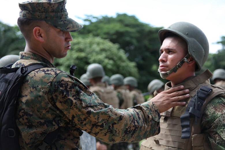 Cpl. Alejandro Melendez, native of San Juan, Puerto Rico, and crew chief of Company A, 2nd Assault Amphibian Battalion, Ground Combat Element of Special-Purpose Marine Air-Ground Task Force Continuing Promise 2010, explains to a Colombian Marine why U.S. Marines wear a throat protector on their personal protective equipment during non-lethal weapons training at Colombian Marine Corps Training Base Covenas in Colombia, Aug. 14, 2010. Marines from USS Iwo Jima conducted subject matter expert exchanges with Colombian Marines Aug. 9-17 in support of Operation Continuing Promise 2010.