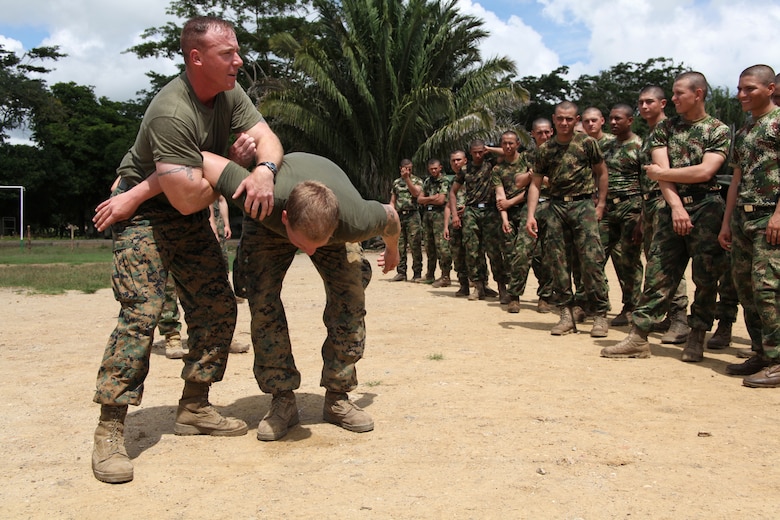 Gunnery Sgt. Miles S. Beasley, native of Spokane, Wash., and platoon sergeant of Company A, 2nd Assault Amphibian Battalion, Ground Combat Element of Special-Purpose Marine Air-Ground Task Force Continuing Promise 2010, instructs Colombian Marines on proper takedowns during non-lethal weapons training at Colombian Marine Corps Training Base Covenas in Colombia, Aug. 14, 2010. Marines from USS Iwo Jima conducted subject matter expert exchanges with Colombian Marines Aug. 9-17 in support of Operation Continuing Promise 2010.