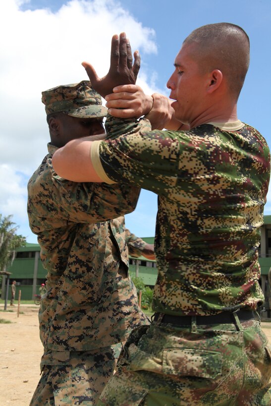 Sgt. Melvain St George, native of Miami, Fla., and supply clerk with Company A, 2nd Assault Amphibian Battalion, Ground Combat Element of Special-Purpose Marine Air-Ground Task Force Continuing Promise 2010, executes takedown techniques with a Colombian Marine during non-lethal weapons training at Colombian Marine Corps Training Base Covenas in Colombia, Aug. 14, 2010. Marines from USS Iwo Jima conducted subject matter expert exchanges with Colombian Marines Aug. 9-17, 2010, in support of Operation Continuing Promise 2010.