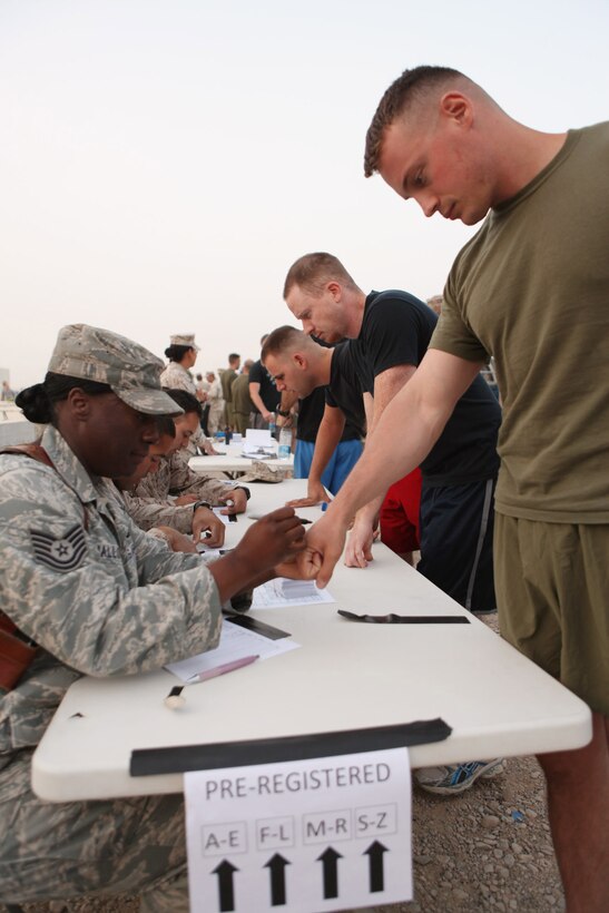 Service members and civilians at Camp Leatherneck, Afghanistan, register for the Maj. Megan McClung Memorial Race, Aug. 14. More than 425 runners participated in the race.