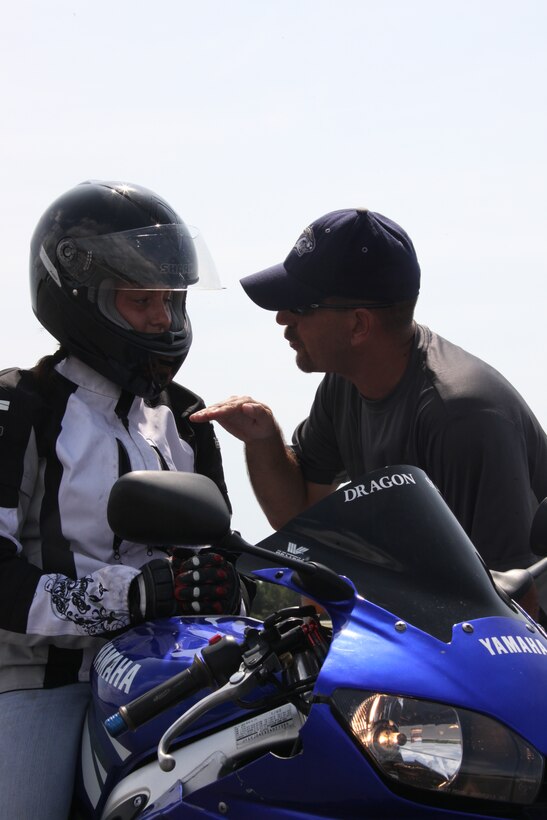Bob Dubois, a rider coach for the Marine Corps Motorcycle Safety Program, gives advice to Cpl. Caitlin N. Liberson, a line mechanic out of New River’s Marine Light Attack Helicopter Squadron 167, at the Advanced Rider Track Day at Marine Corps Auxiliary Landing Field Bogue Aug. 14.