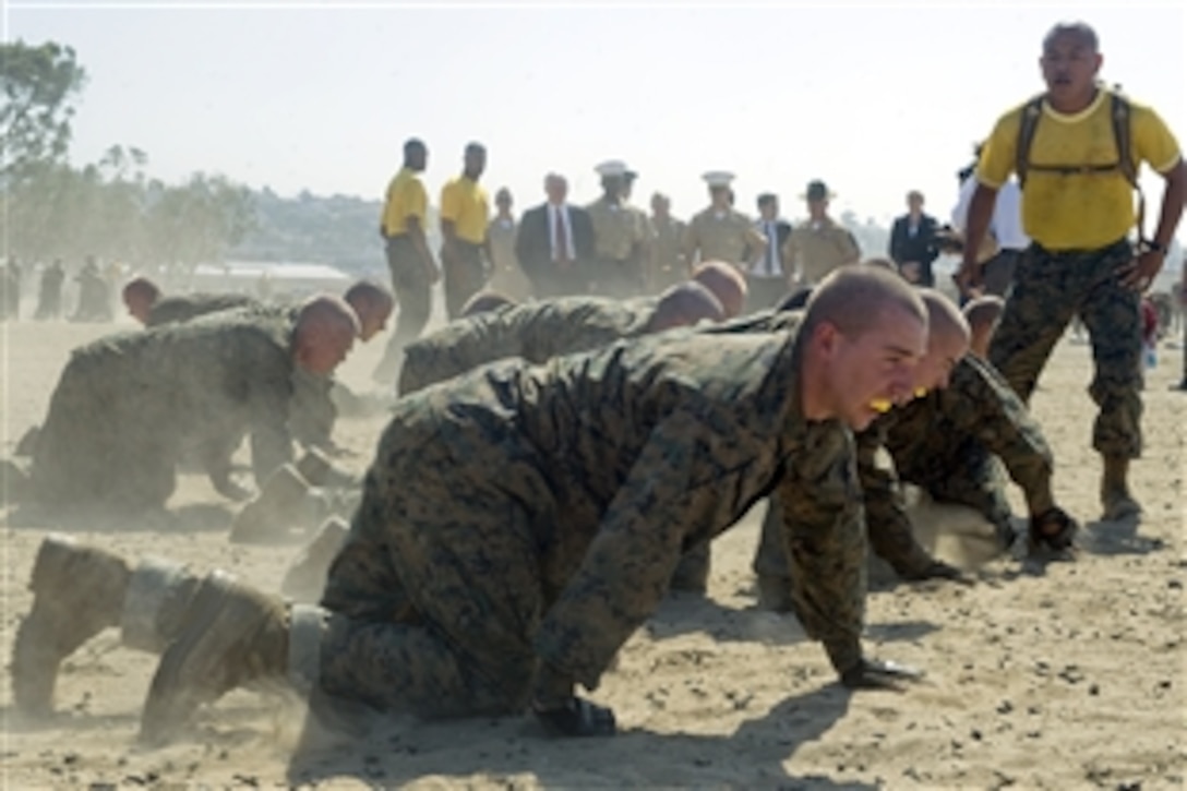 Defense Secretary Robert M. Gates observes while a Marine drill instructor trains recruits on the Combat Conditioning Field, Marine Corp Recruit Depot in San Diego, Aug. 13, 2010.  