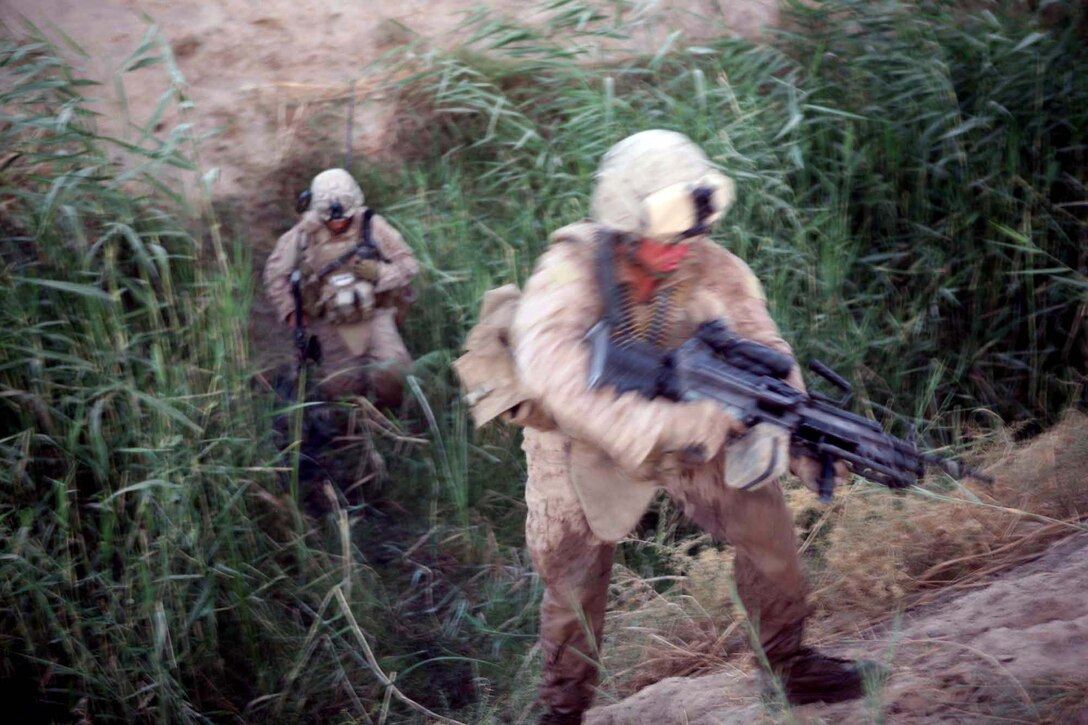 Lance Cpl. Joshua L. Hamilton, a squad automatic weapon gunner with Echo Company, 2nd Battalion, 6th Marine Regiment, climbs up a hill during a patrol through Marjah, Afghanistan, Aug. 15, 2010. Hamilton, 25, is from Carthage, N.Y.