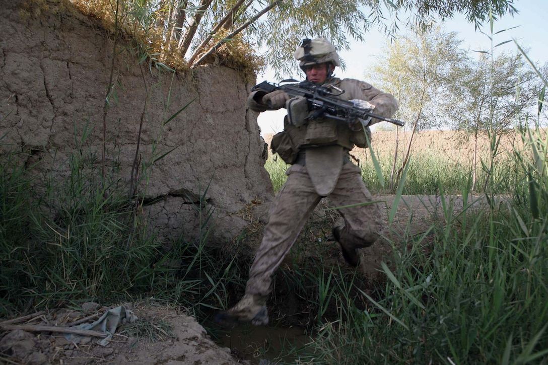 Lance Cpl. Joshua L. Hamilton, a squad automatic gunner with Echo Company, 2nd Battalion, 6th Marine Regiment, makes a leap of faith across a canal during a patrol through Marjah, Afghanistan, Aug. 15, 2010. Hamilton, 25, is from Carthage, N.Y.