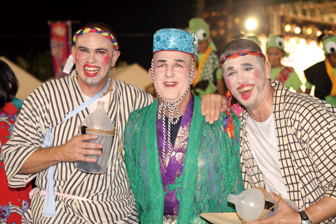 From left to right, Lt. Col. Ian Wallace, Marine Corps Air Station Futenma executive officer, Col. Dale M. Smith, MCAS Futenma commanding officer, and Chief Warrant Officer Brent A. DeBusk, aircraft rescue and fire fighting/ aircraft recovery officer in charge, laugh and enjoy the applause from the audience after their team's performance in the 33rd Ginowan Hagoromo Festival Kachashi Dance contest, Aug. 15 at Ginowan Seaside Park, one of three major festivals held on Okinawa.
