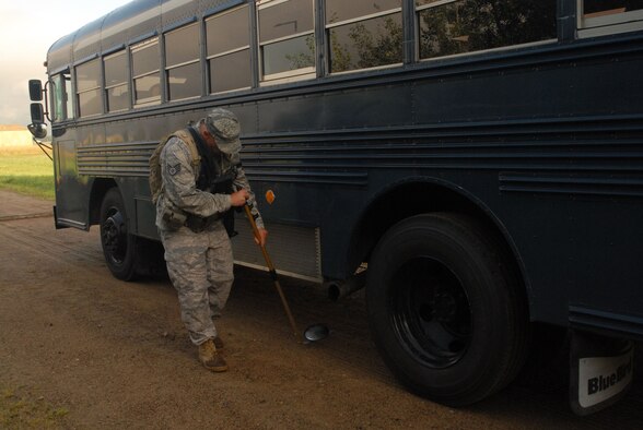 Staff Sgt. Daven Dekok of the 185th Air Refueling Wing, Security Forces inspects the undercarage of a bus for things out of the ordinary during an Operational Readiness Exercise (ORE) at Volk Field, Wiscosin, 11 August, 2010. (US Air Force Photo by Tech. Sgt. Brian Cox)