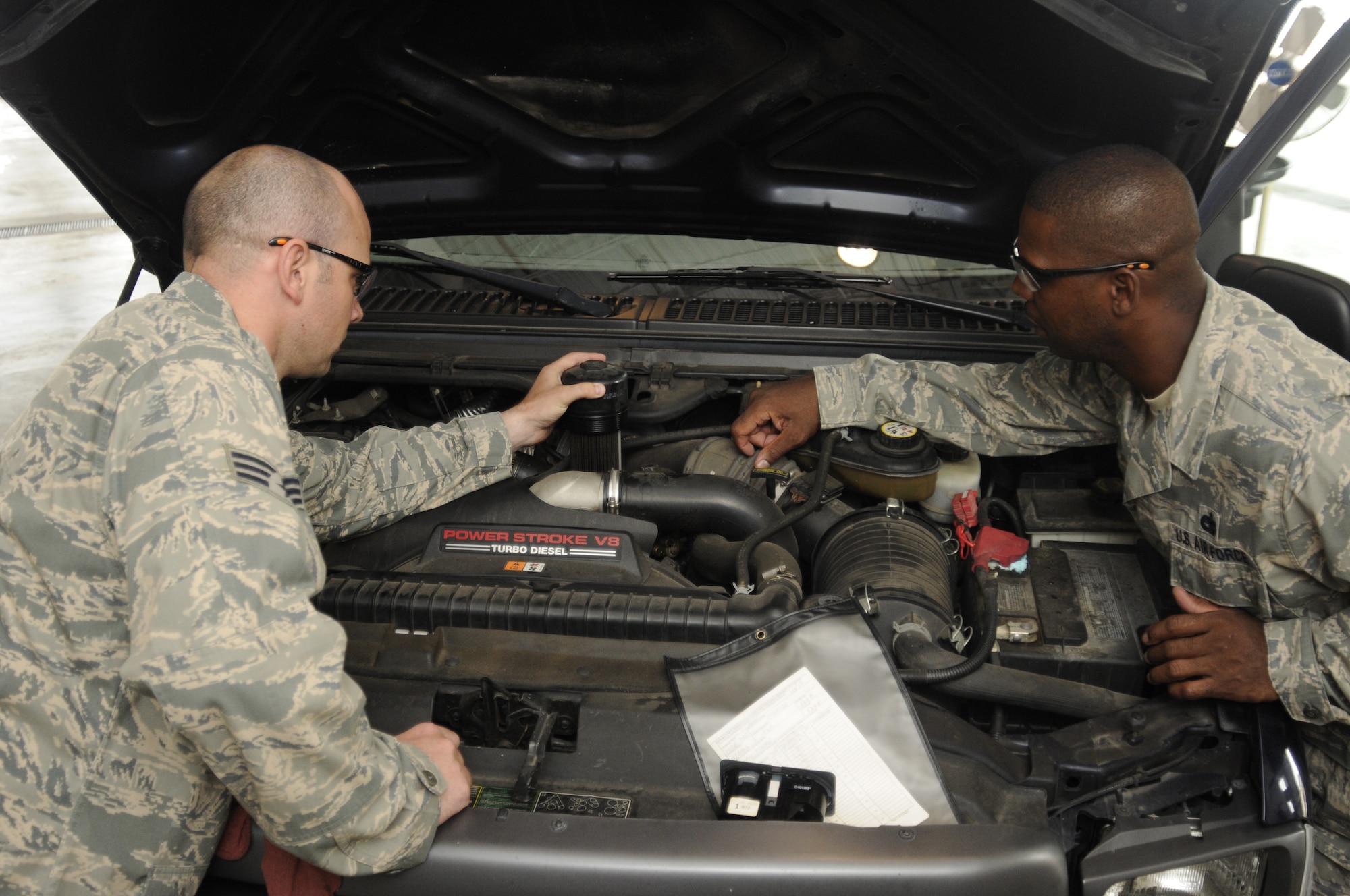 Senior Airman Kristian Magro and Technical Sgt. Jerry Byrdo inspect the engine on a pick-up truck that was operated utilizing a blend of synthetic fuel as part of an alternative fuels test at Selfridge Air National Guard Base, Aug. 10, 2010. The test on the Fischer-Tropsch blend of fuel concluded in July. Selfridge has been the site of a number of test projects of alternative fuels for vehicles and other ground equipment over the last several years. (U.S. Air Force photo by TSgt. David Kujawa) (RELEASED)